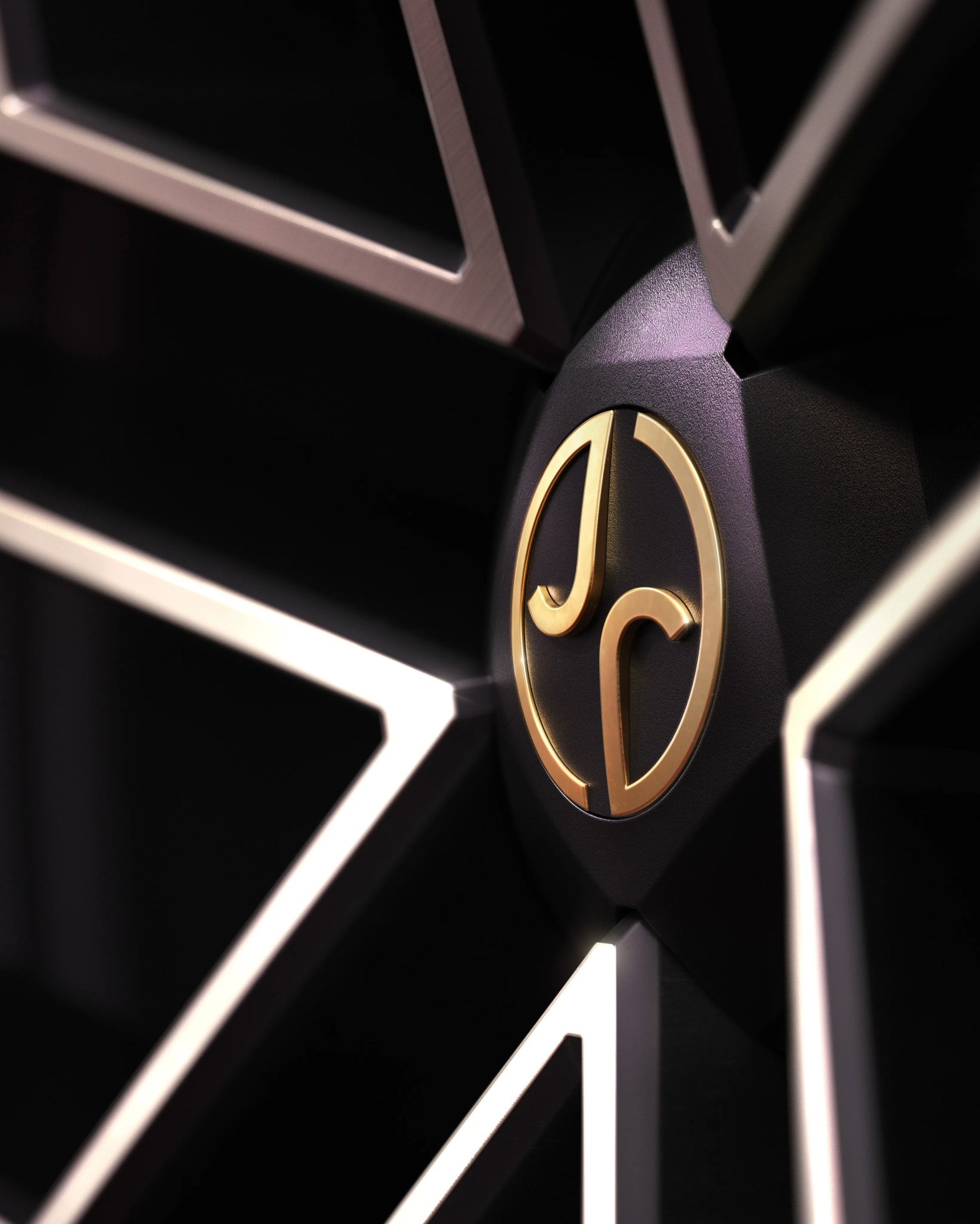 Close-up of a black car wheel rim with a gold "JD" logo at the center.