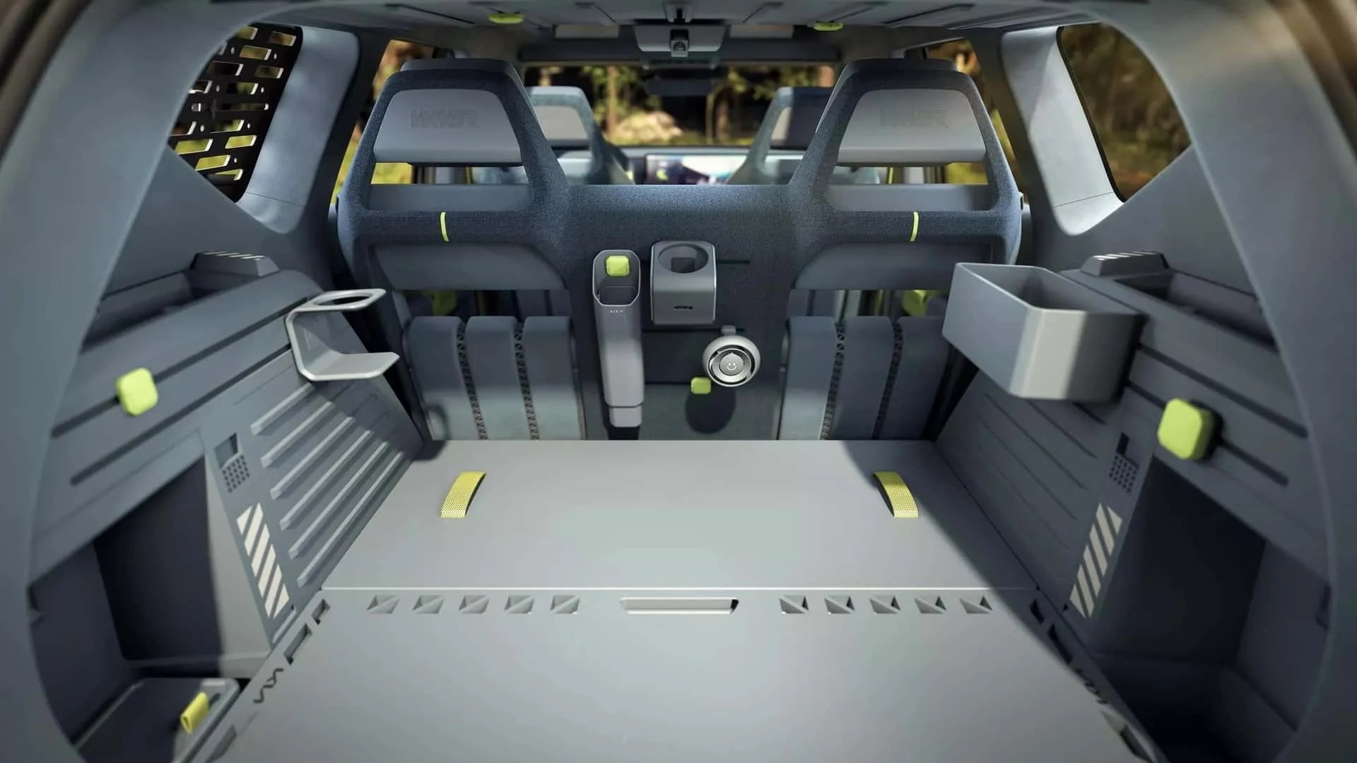 Interior view of a gray modular vehicle cargo area with foldable seats and lime green accents.