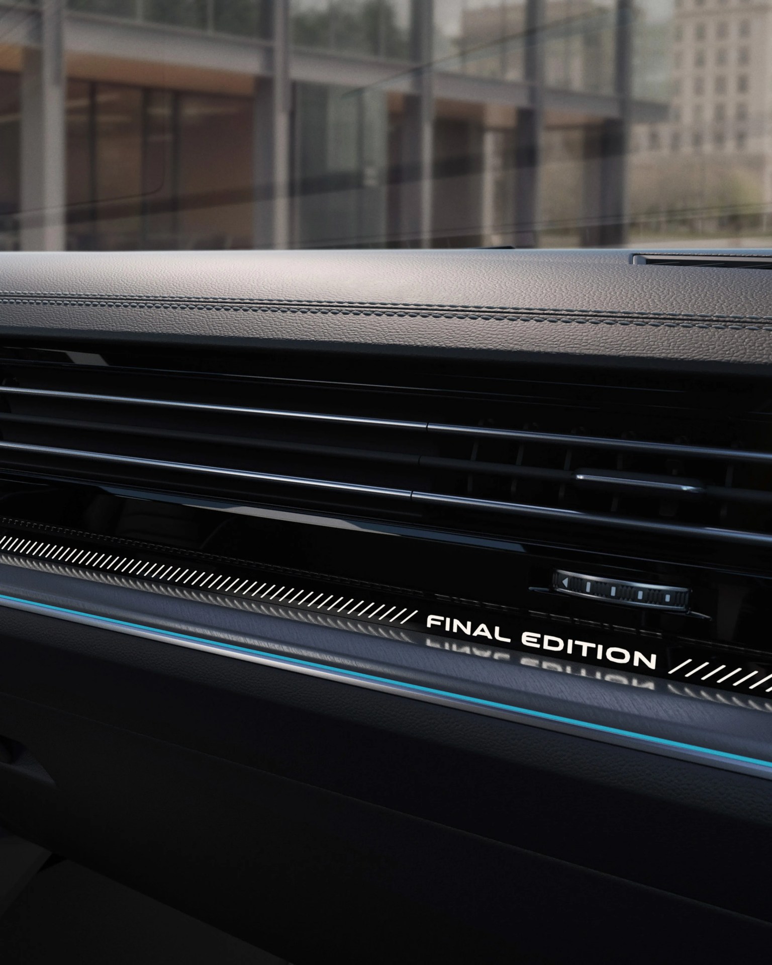 Close-up of a car dashboard with black leather trim and illuminated "FINAL EDITION" text near the air vent.
