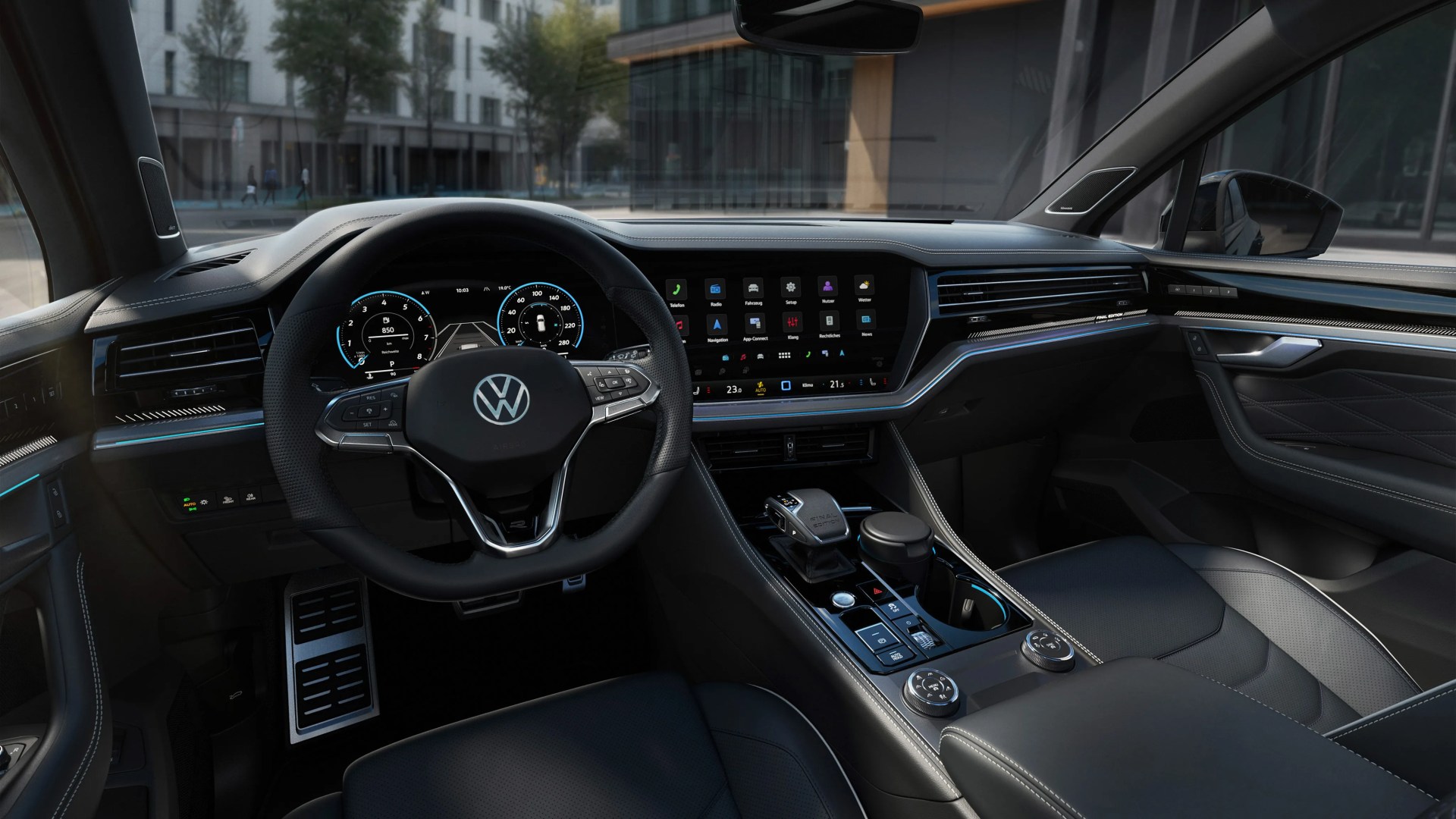 Interior of a Volkswagen car featuring a black leather steering wheel with VW logo, digital dashboard, and touchscreen infotainment system.