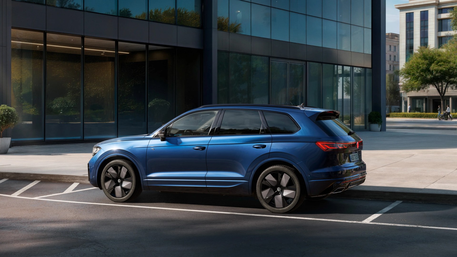 Blue Volkswagen SUV with black alloy wheels parked in an urban setting near a glass building.