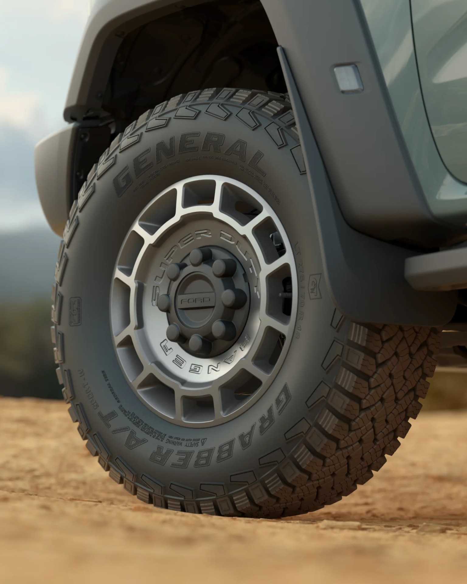 Off-road tire with "General Grabber A/T" tread mounted on a silver Ford Super Duty Ranger wheel.