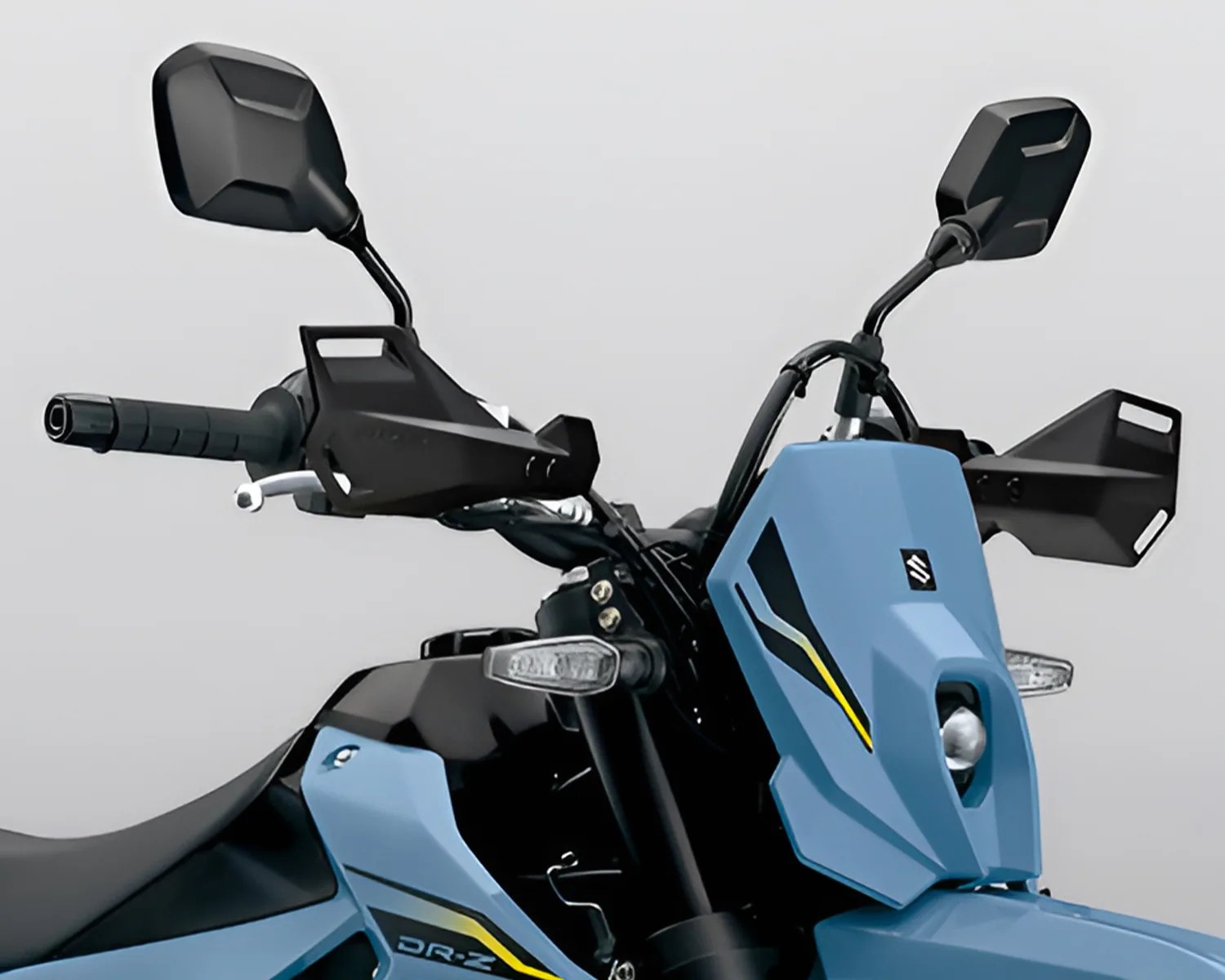 Close-up of a blue Suzuki DR-Z motorcycle front with black handguards, mirrors, and a single headlight.