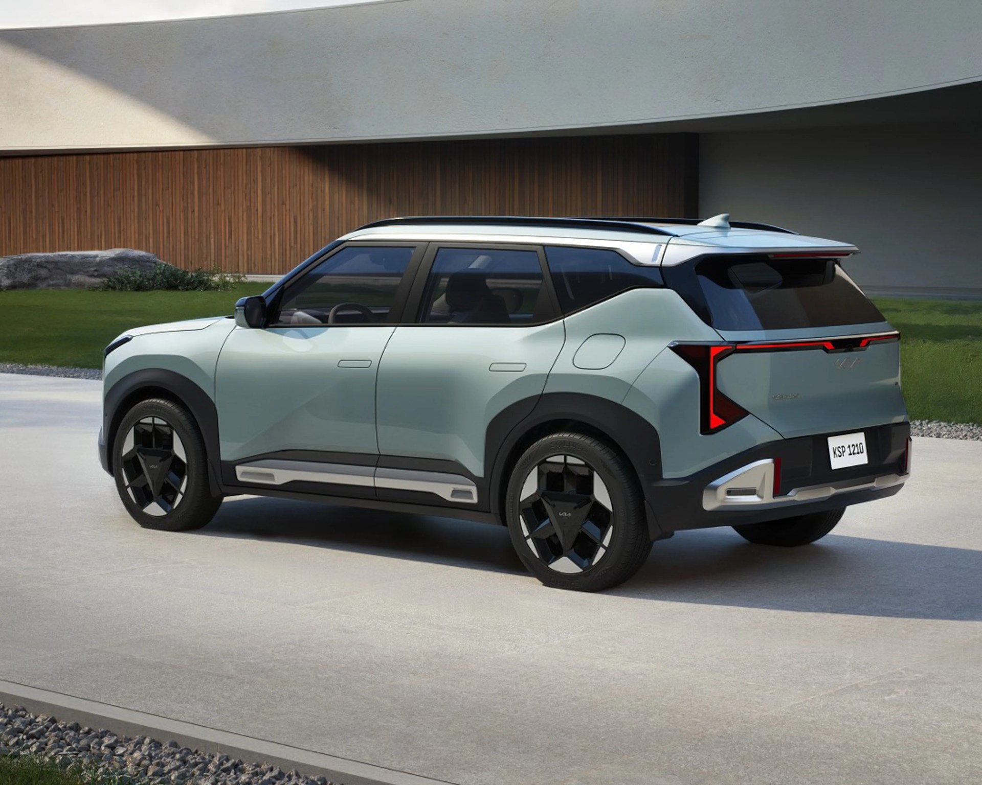 Light green compact SUV with black roof, angular rear LED lights, and black geometric wheels parked on a concrete driveway.