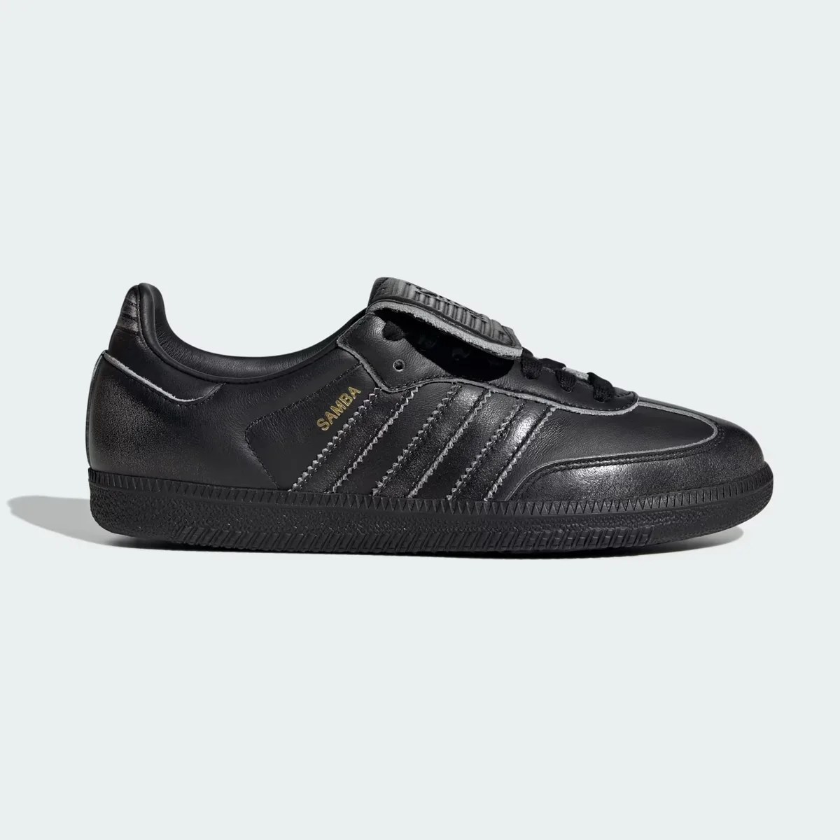 Black Adidas Samba leather sneaker with black sole and gold "SAMBA" text on the side.