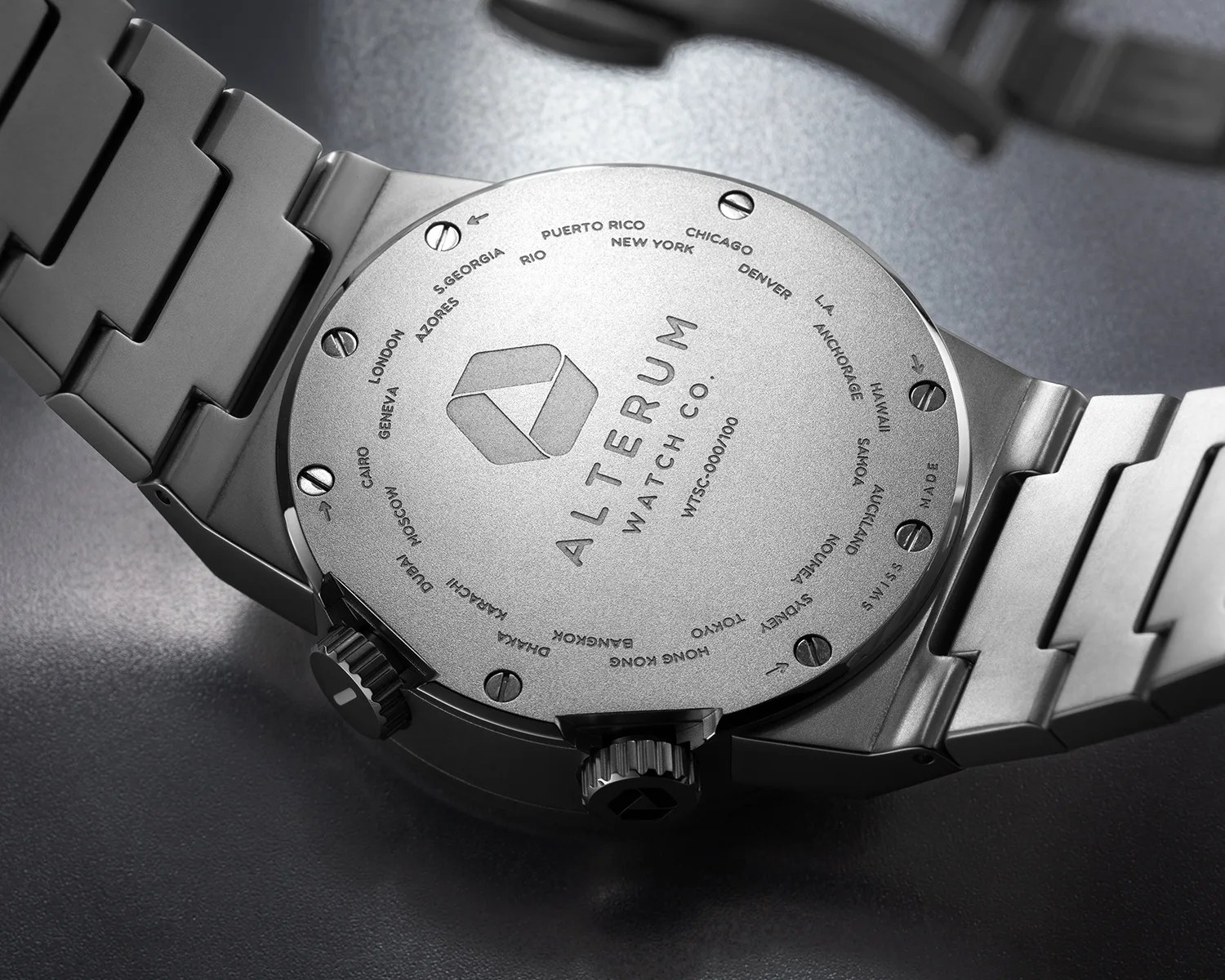 Silver stainless steel watch back with city names engraved around the edge and "ALTERUM WATCH CO." logo in the center.