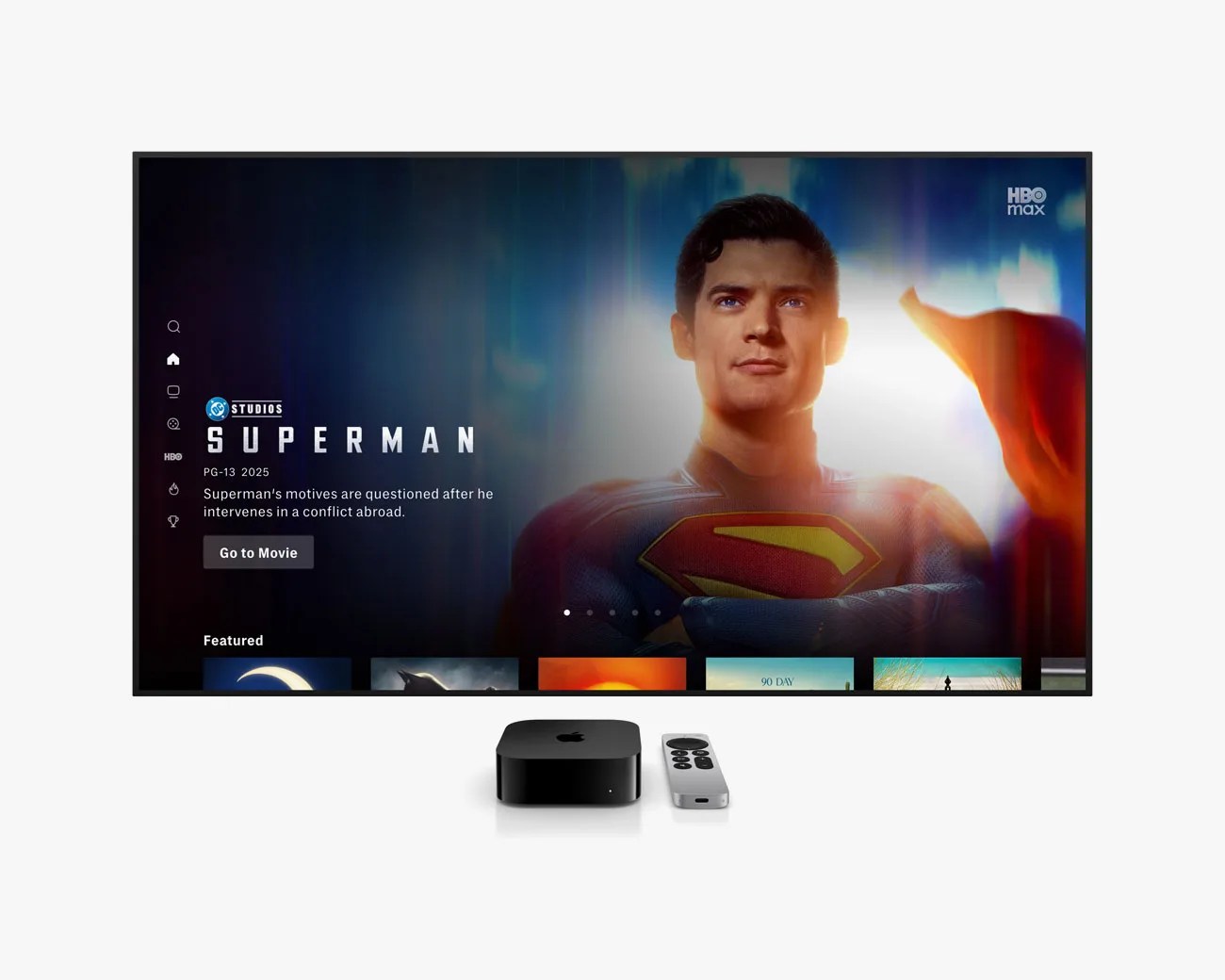Black Apple TV box and silver remote in front of a TV screen displaying the Superman movie on HBO Max.