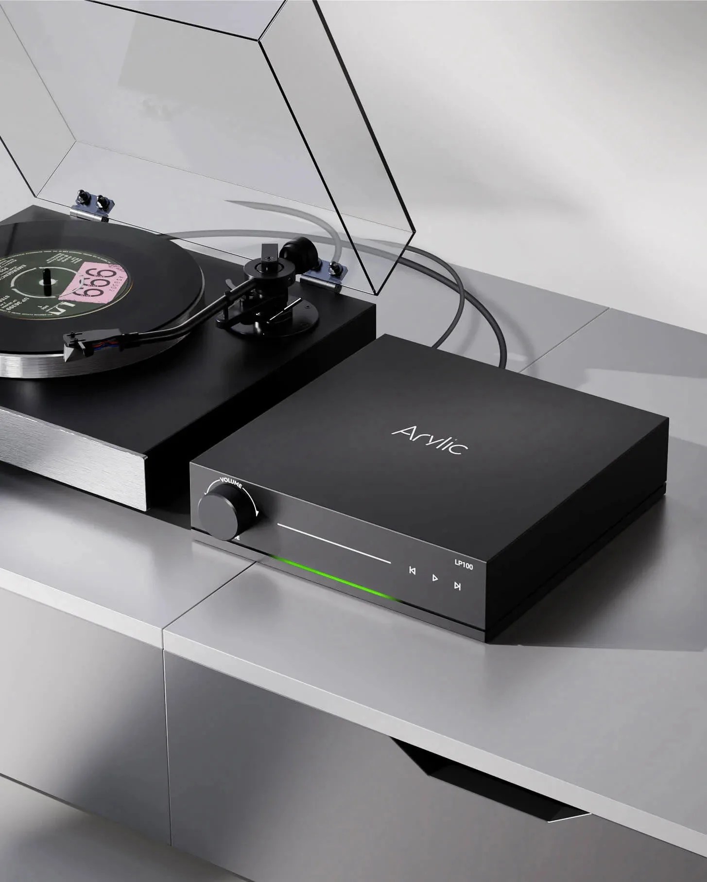 Black Acrylic LP100 turntable with volume knob and transparent dust cover on a gray surface.