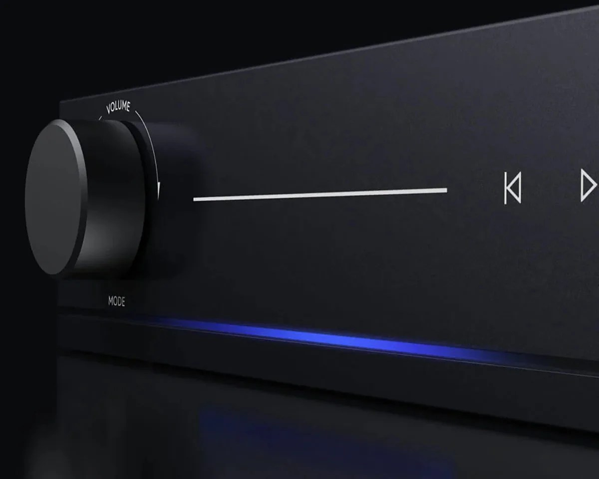 Black audio receiver with large volume knob, white playback control icons, and blue LED light strip.