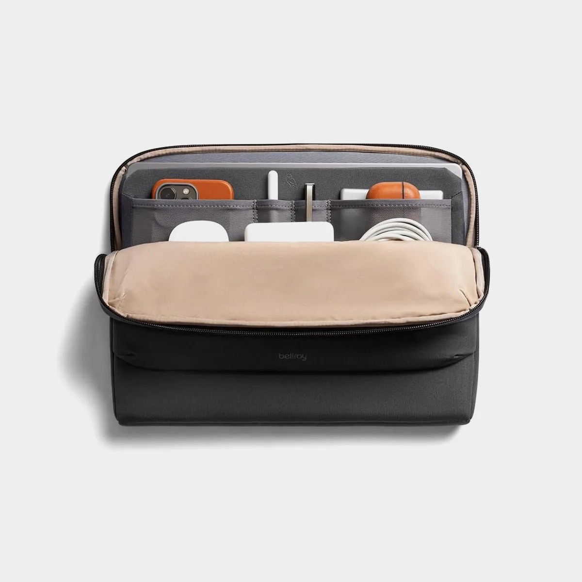 Black and beige tech organizer pouch with multiple compartments holding a phone, charger, cables, and earbuds.