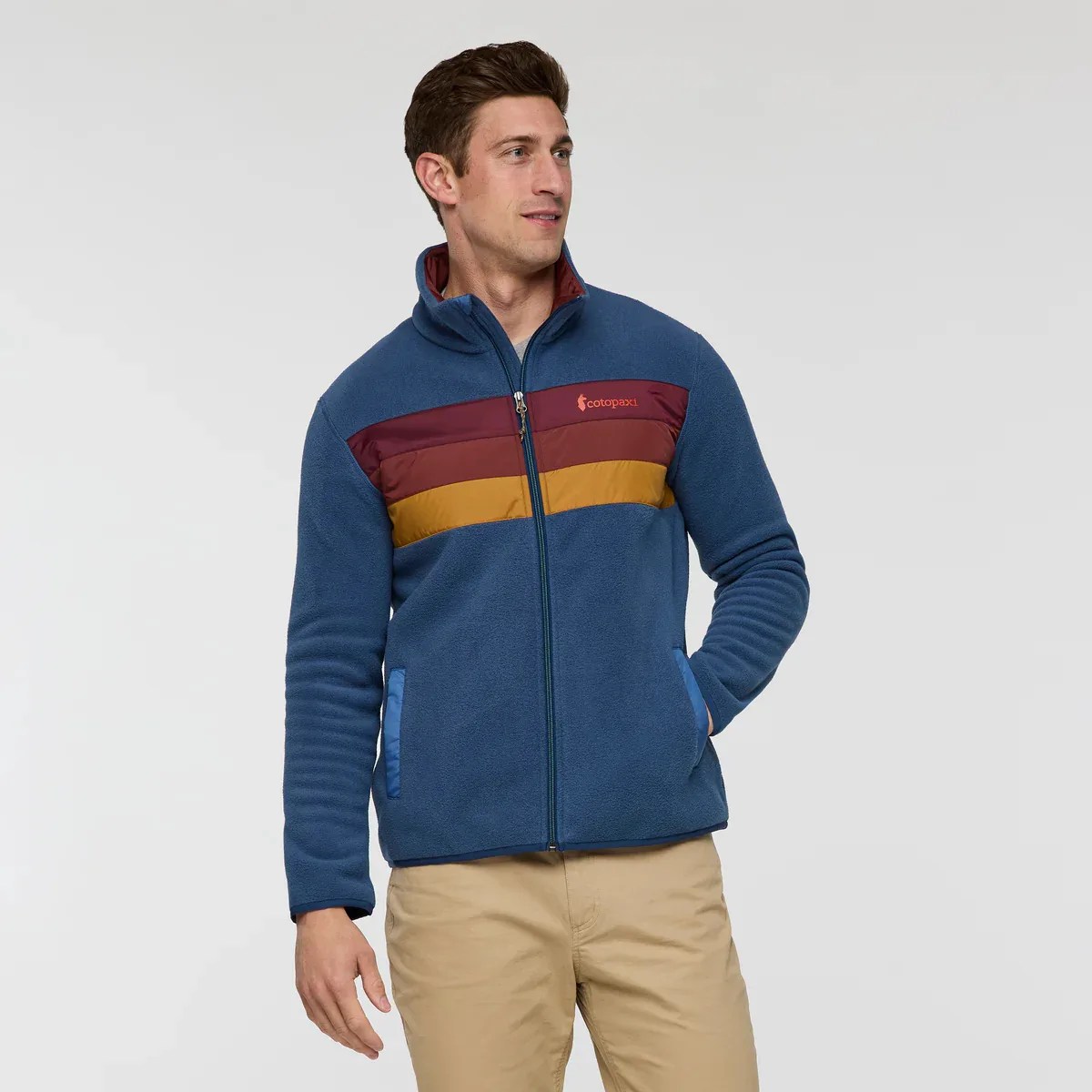Blue fleece jacket with maroon and mustard horizontal stripes and zippered front worn by a person.