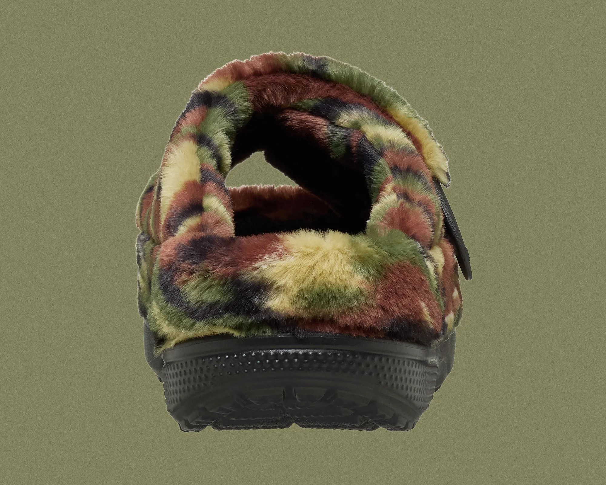 Back view of a fuzzy slipper with a multicolor camouflage pattern and black rubber sole.