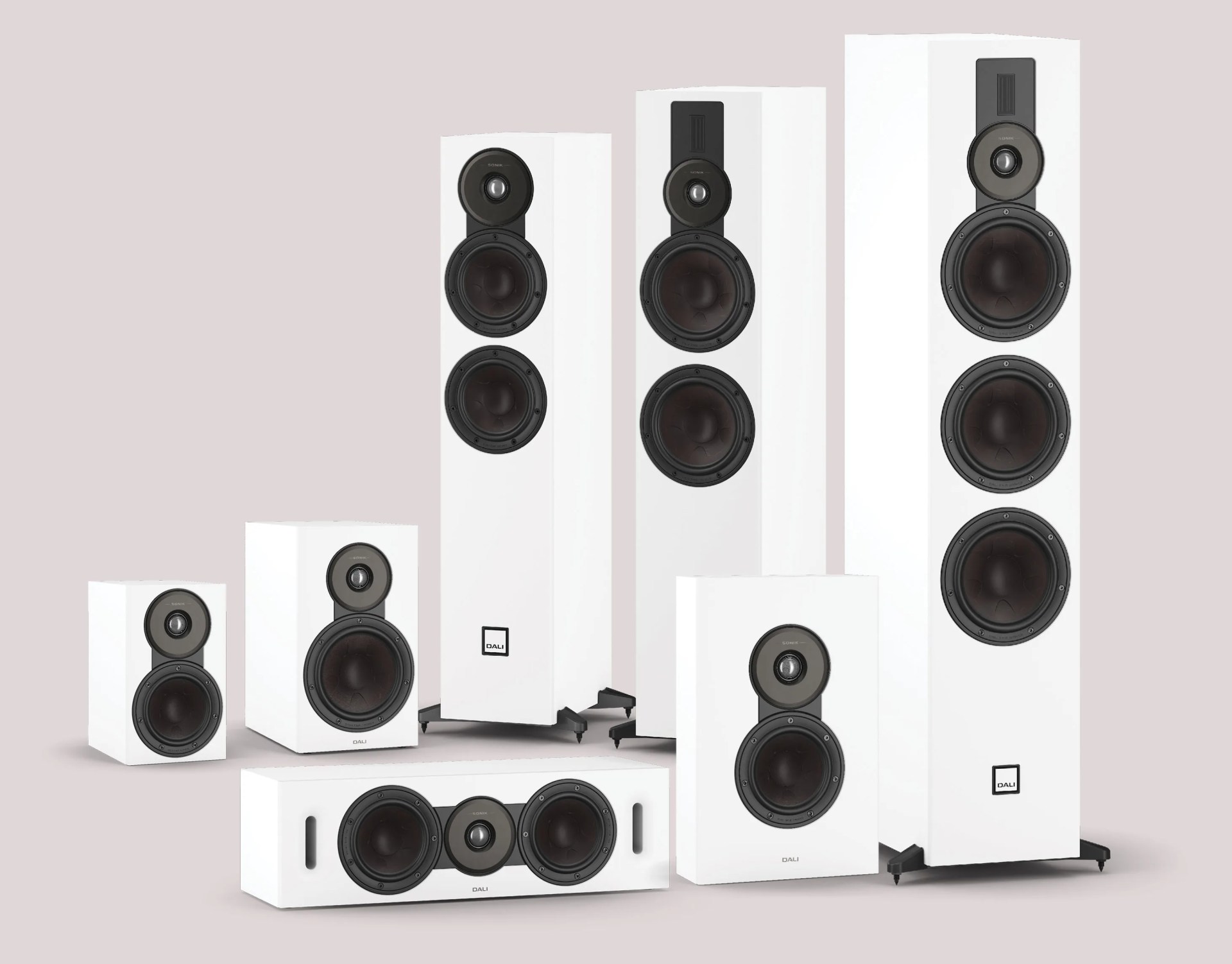 Set of white DALI speakers including two tall floor-standing models, three bookshelf speakers, and one horizontal center speaker.