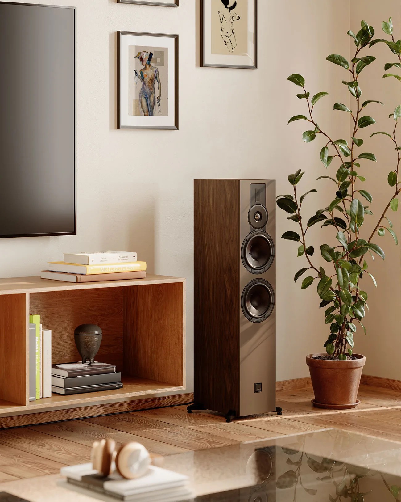 Tall floor-standing speaker with wood finish and black front panel next to a wooden shelf and potted plant.