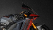 Close-up of a black Ducati motorcycle front with red stripes and gold front suspension forks.