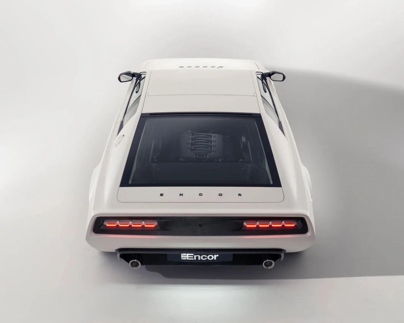 White Encor sports car rear view with visible engine under glass and illuminated taillights.