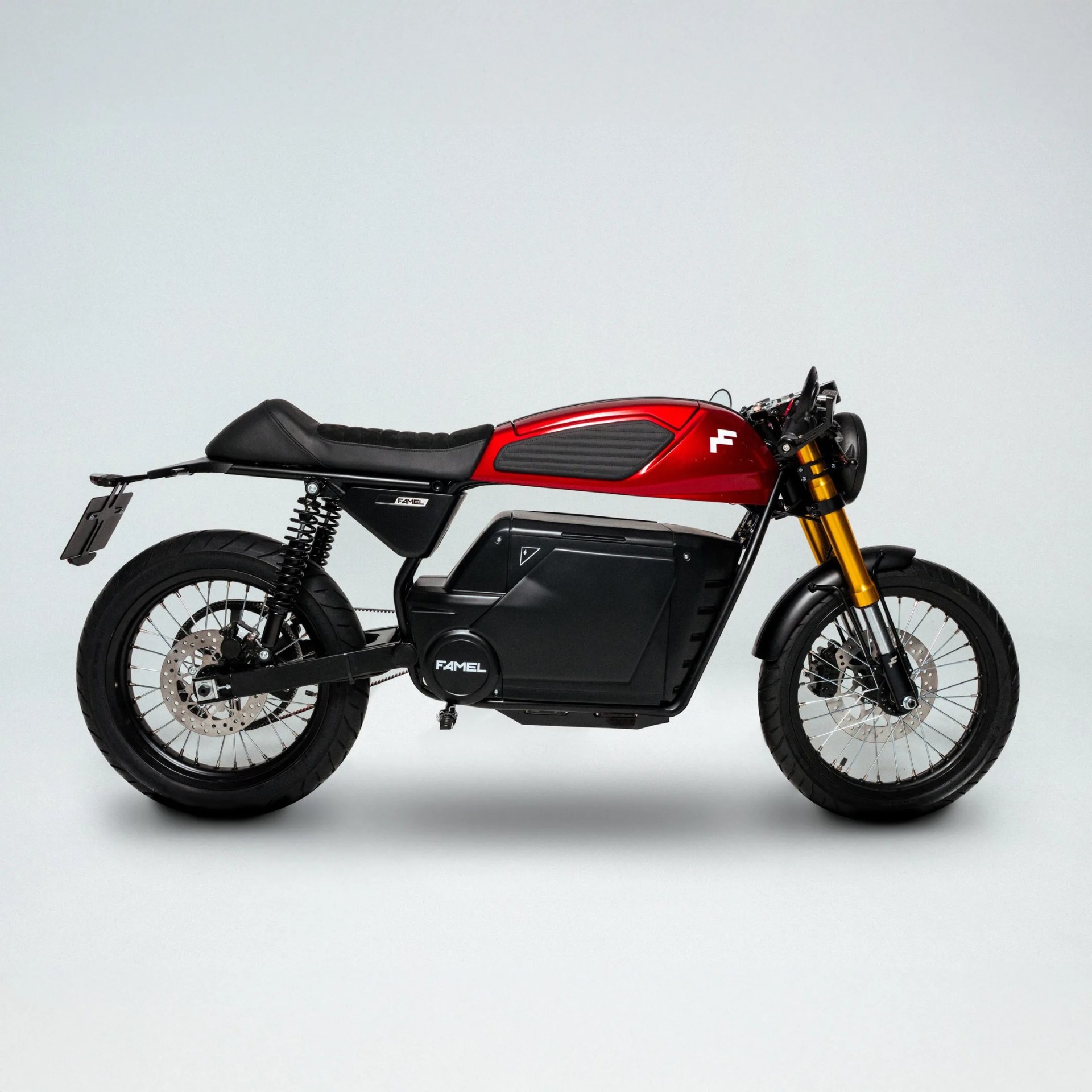 Red and black electric motorcycle with gold front forks and black seat on a white background.