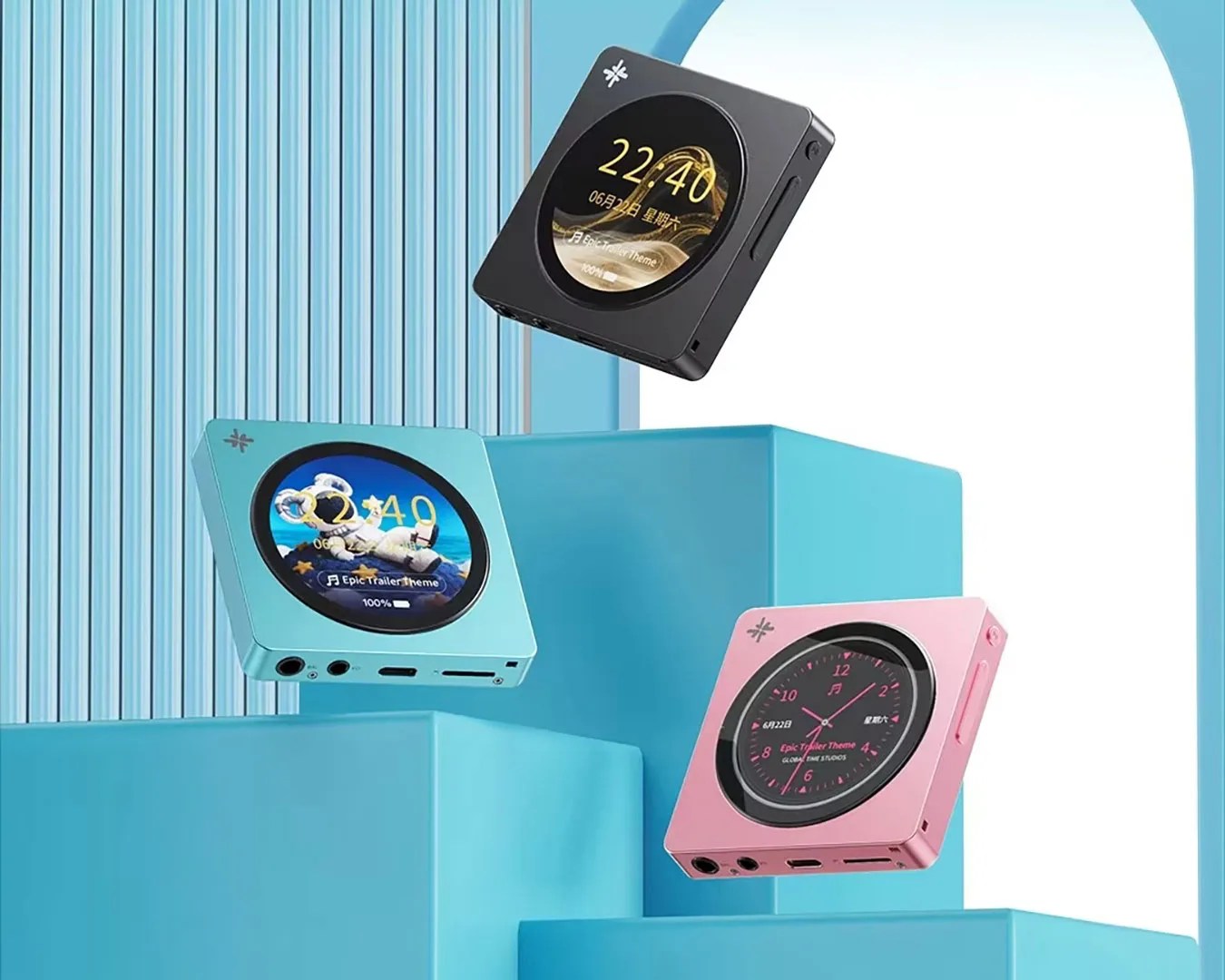 Three square digital music players in black, blue, and pink with circular screens displaying different watch faces, floating above blue geometric platforms.