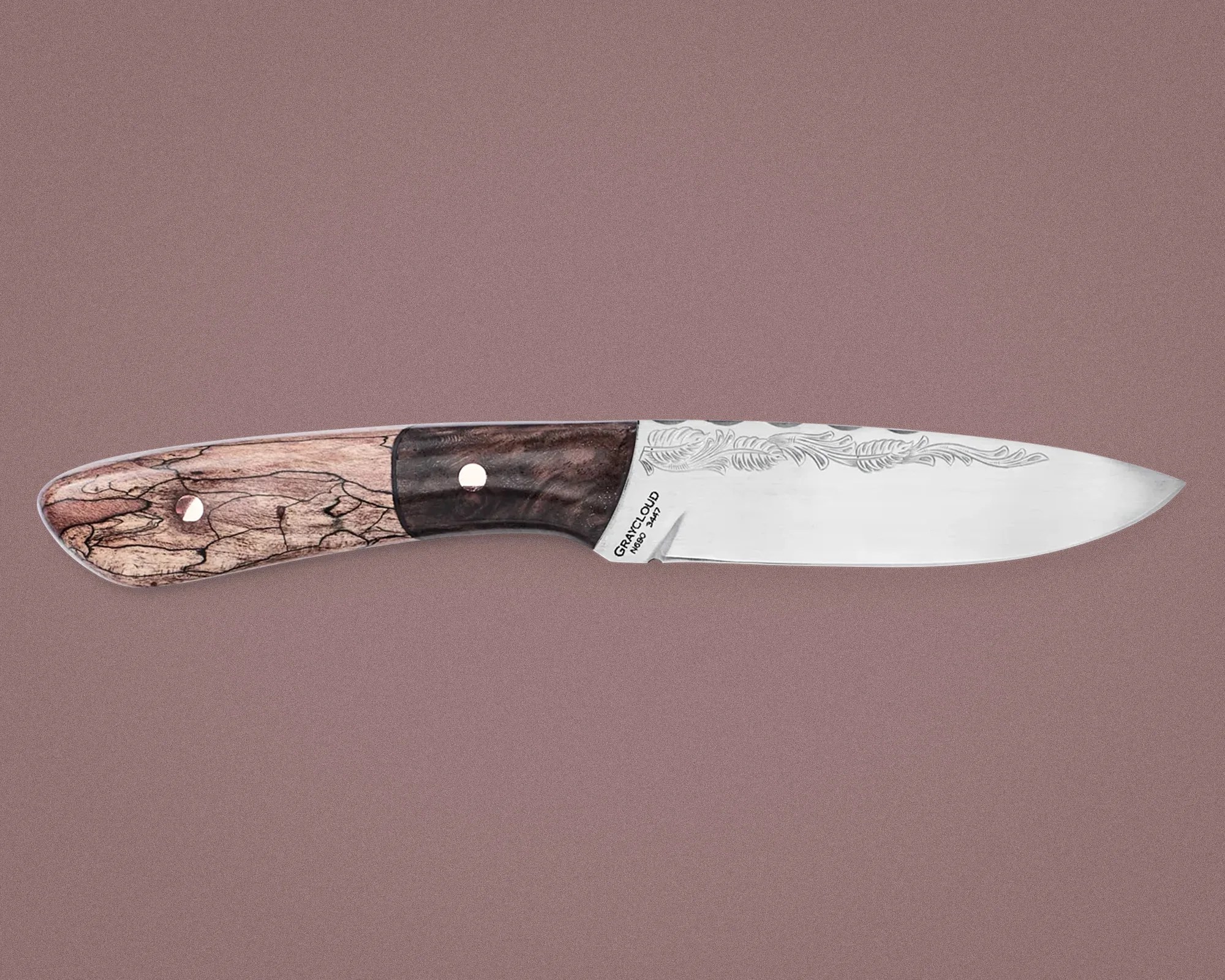 Knife with a polished steel blade engraved with a feather design and a two-tone wooden handle.