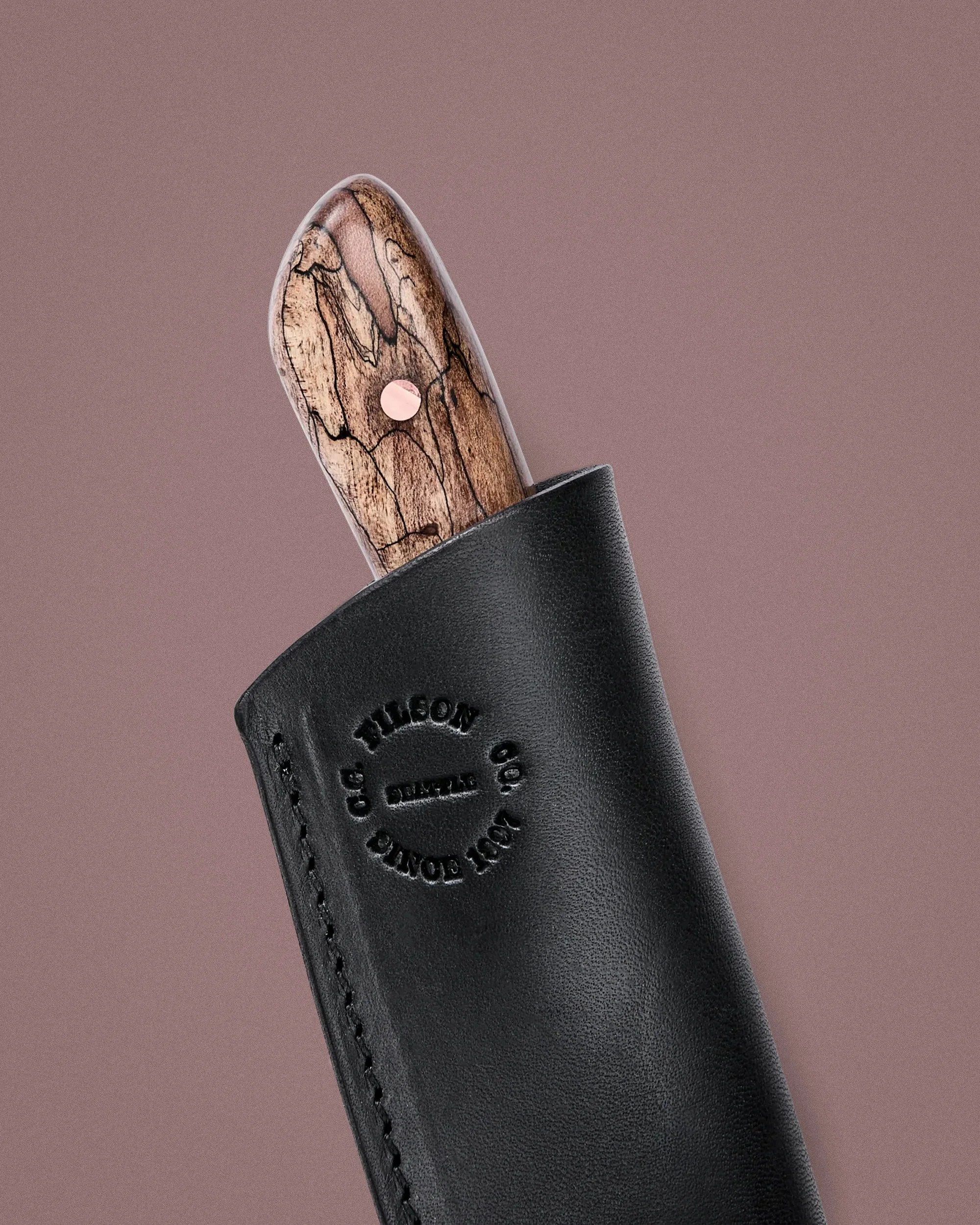 Knife with a polished wood handle partially sheathed in black leather stamped with "Tilson Co. Since 1901.