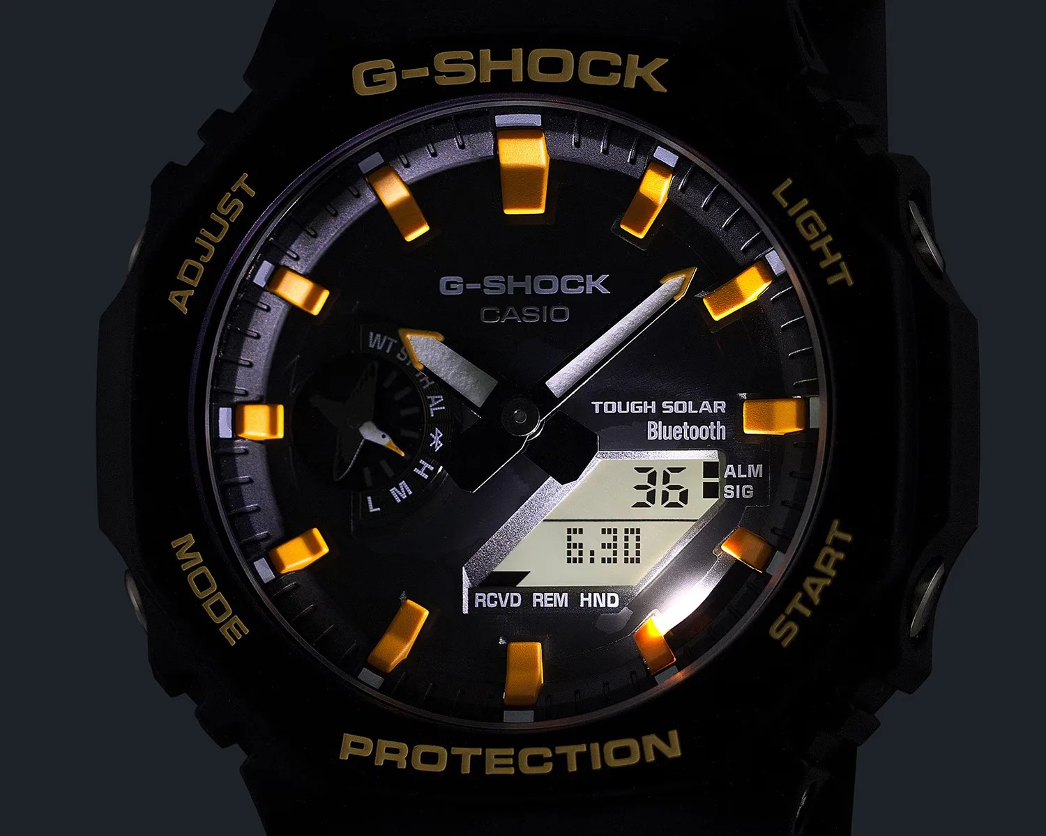 Black Casio G-Shock watch face with yellow hour markers and digital display showing date and time.