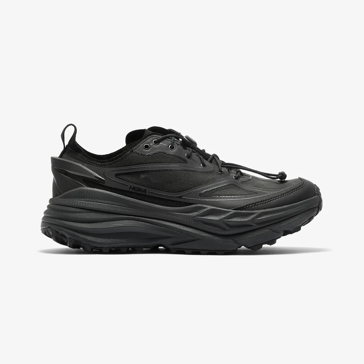 Black Hoka running shoe with thick cushioned sole and quick-lace system shown from the side.