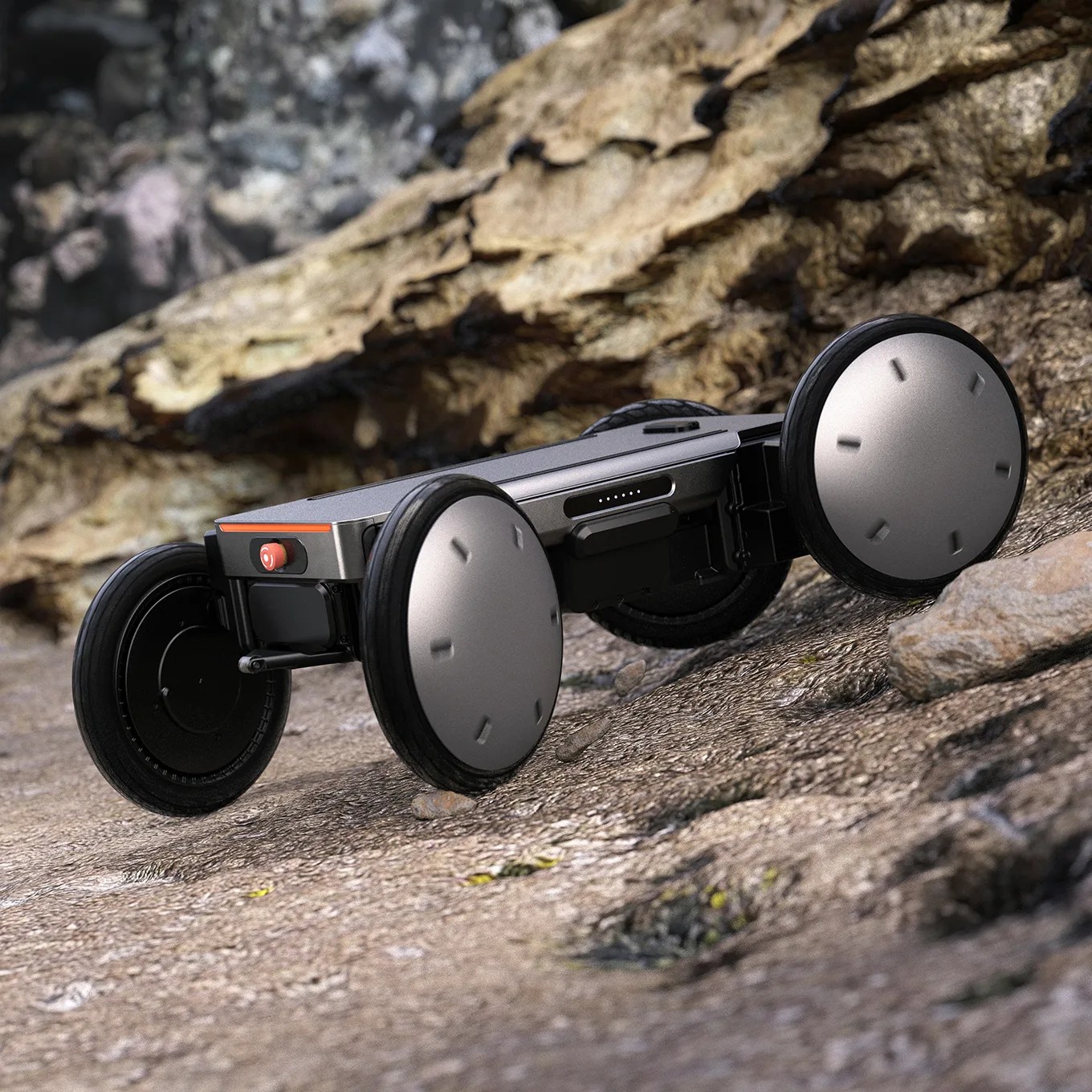 Four-wheeled robotic device with large silver and black wheels on a rocky outdoor surface.