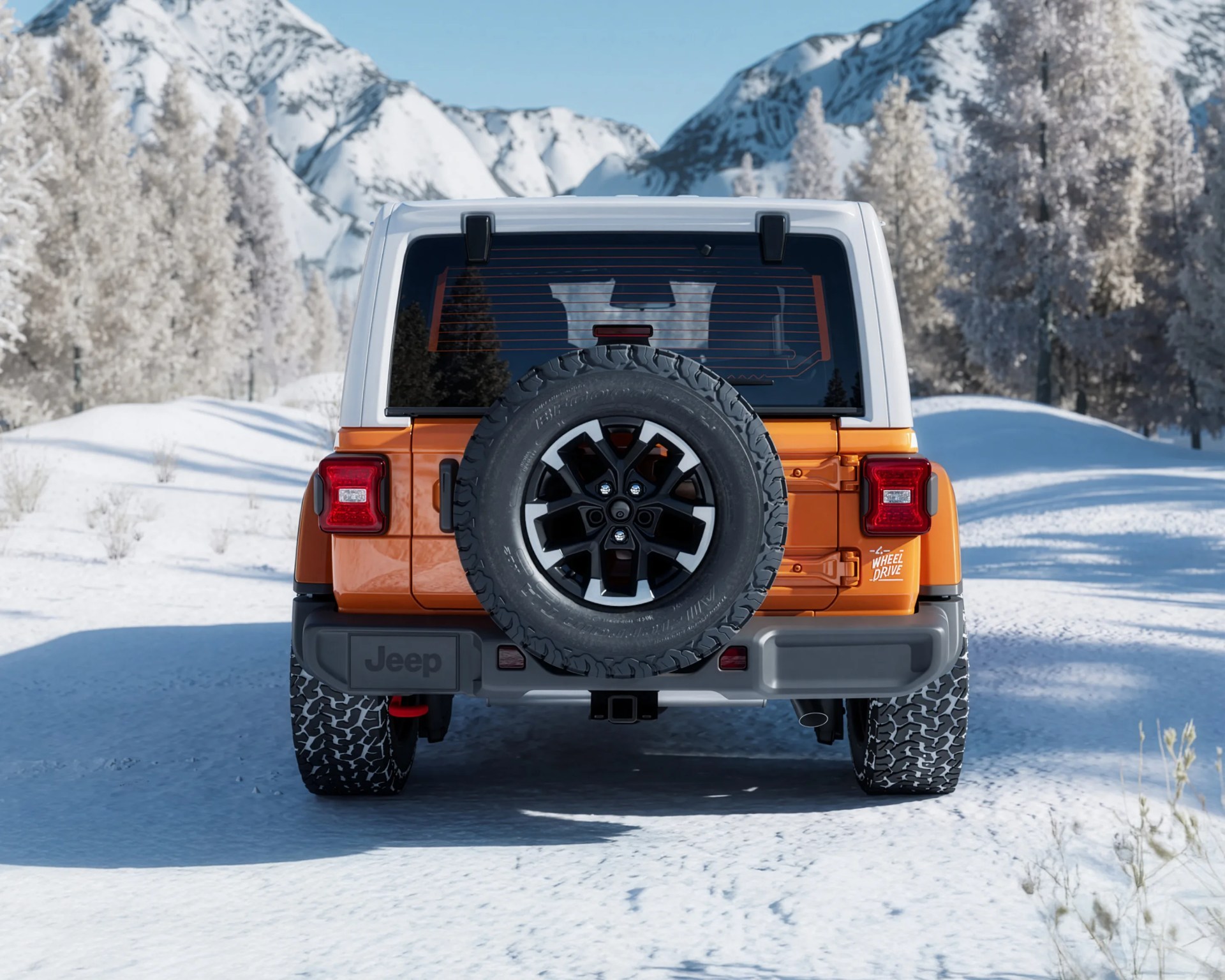 Orange and white Jeep with spare tire mounted on the back, parked on a snowy road with snow-covered trees and mountains.