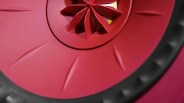 Close-up of a red circular object with a black textured edge and a central star-shaped design.