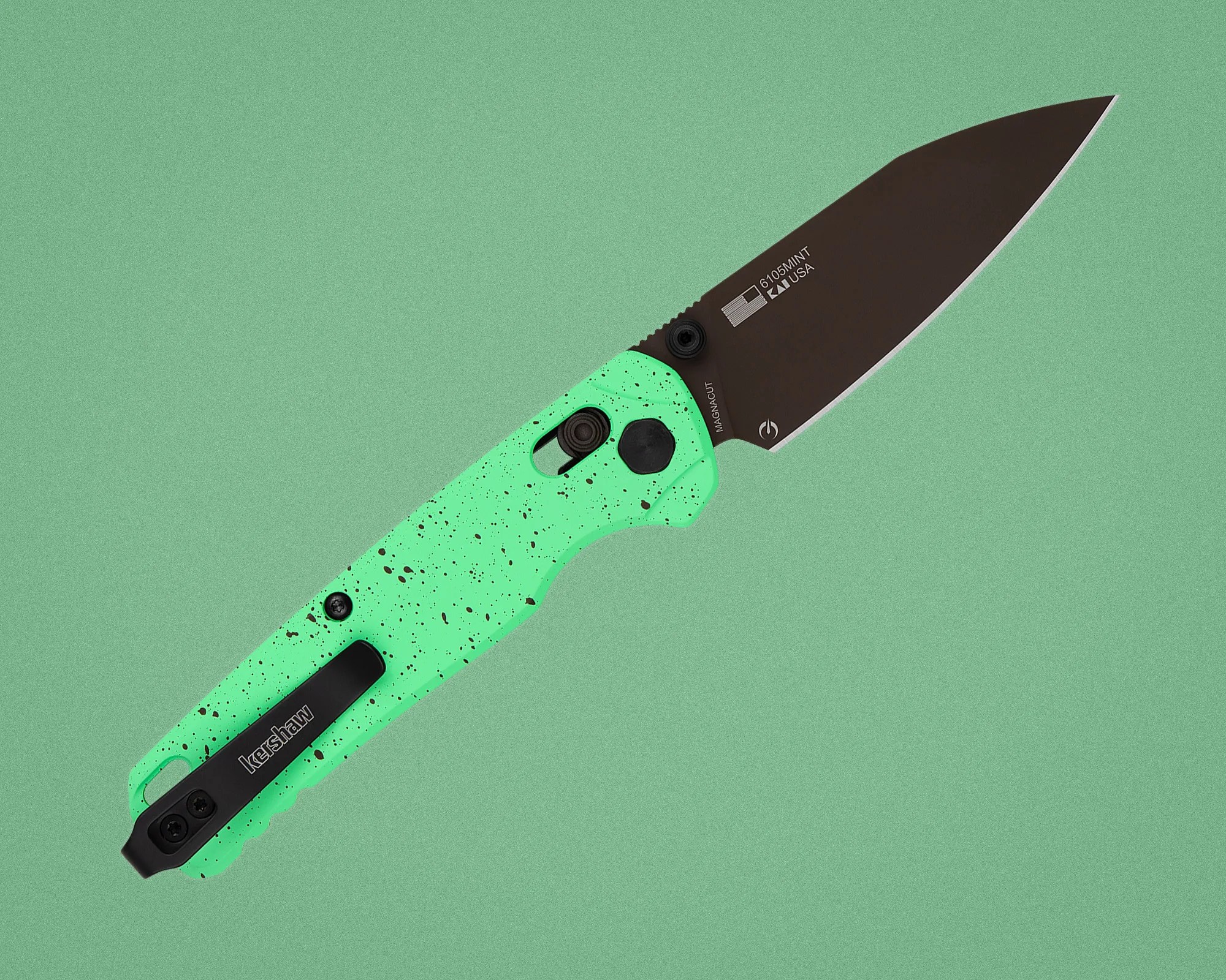 Folding knife with black blade and mint green speckled handle on a green background.