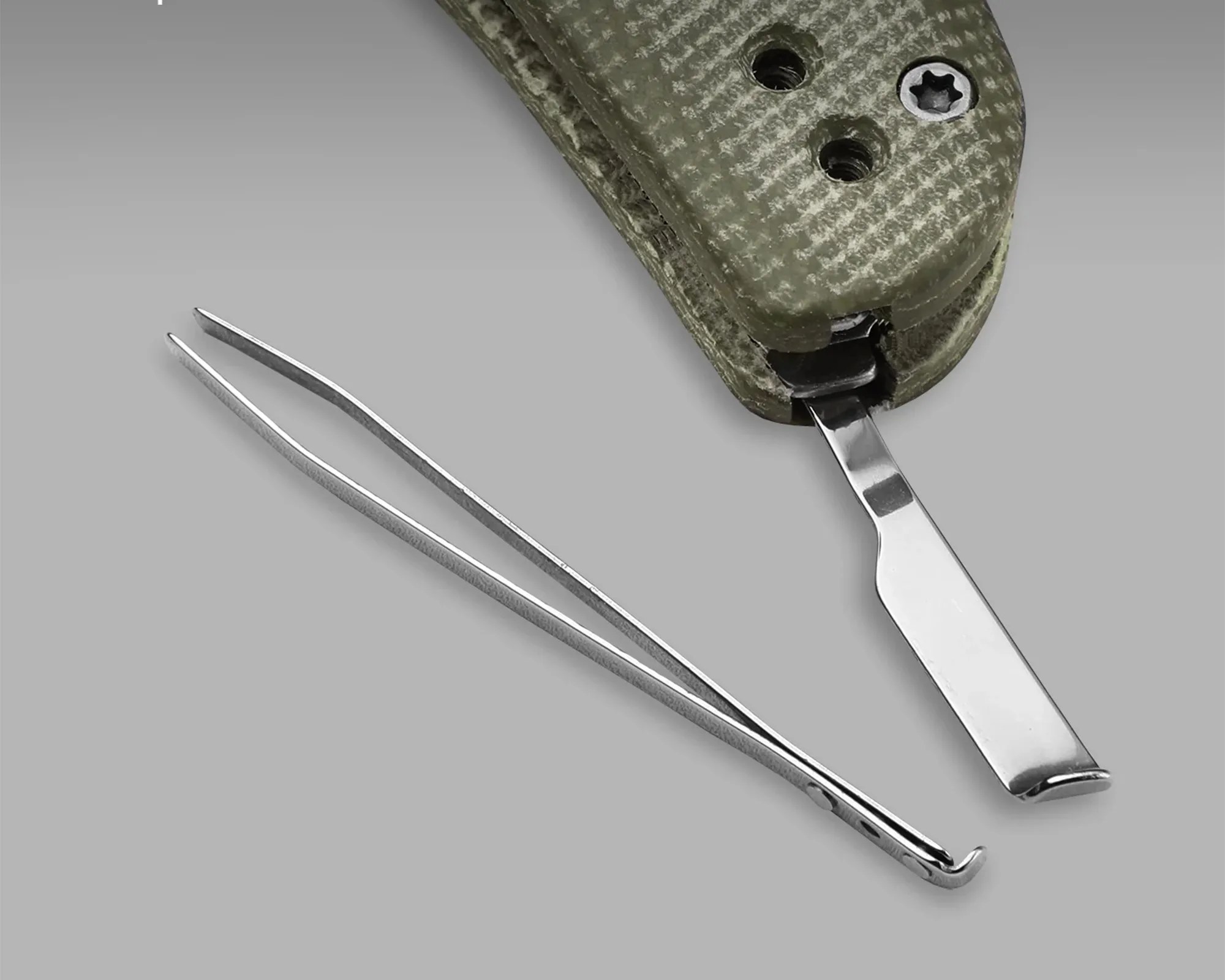 Silver metal tweezers next to a partially visible green textured folding tool with a flat metal blade.