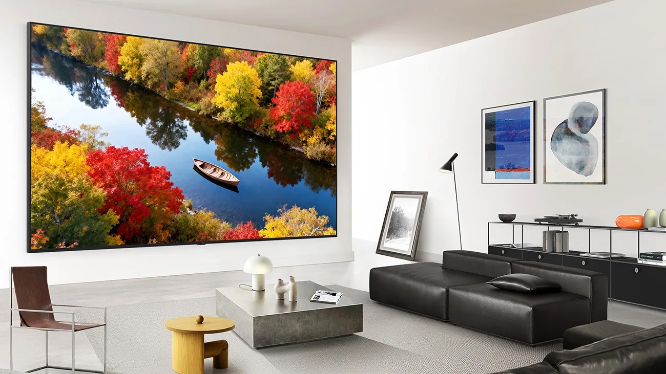 Modern living room with a large wall-mounted TV displaying a river with colorful autumn trees and a wooden boat.