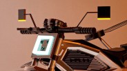 Close-up of a motorcycle handlebar with square rearview mirrors and a bright square headlight.