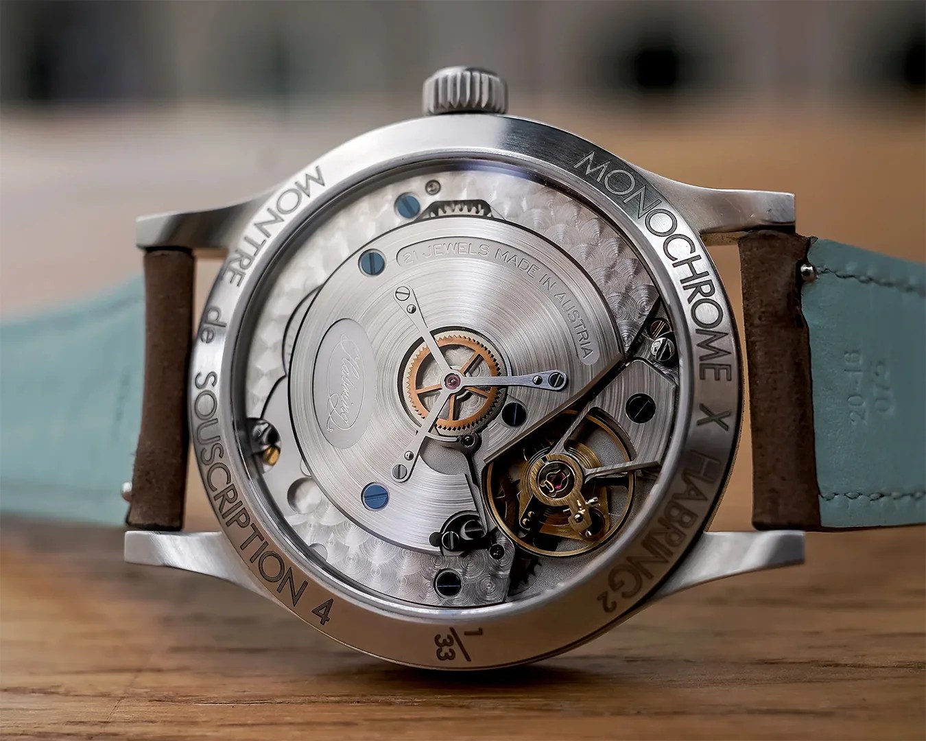 Close-up of the back of a Monochrome X Habring&sup2; wristwatch showing the intricate mechanical movement and engravings on the metal case.