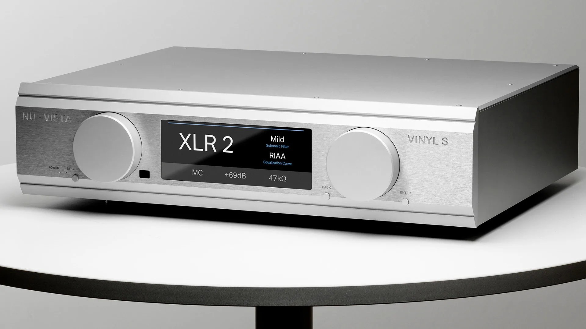 Silver Nu-Vista Vinyl S audio preamplifier with digital display and two large control knobs on a white round table.
