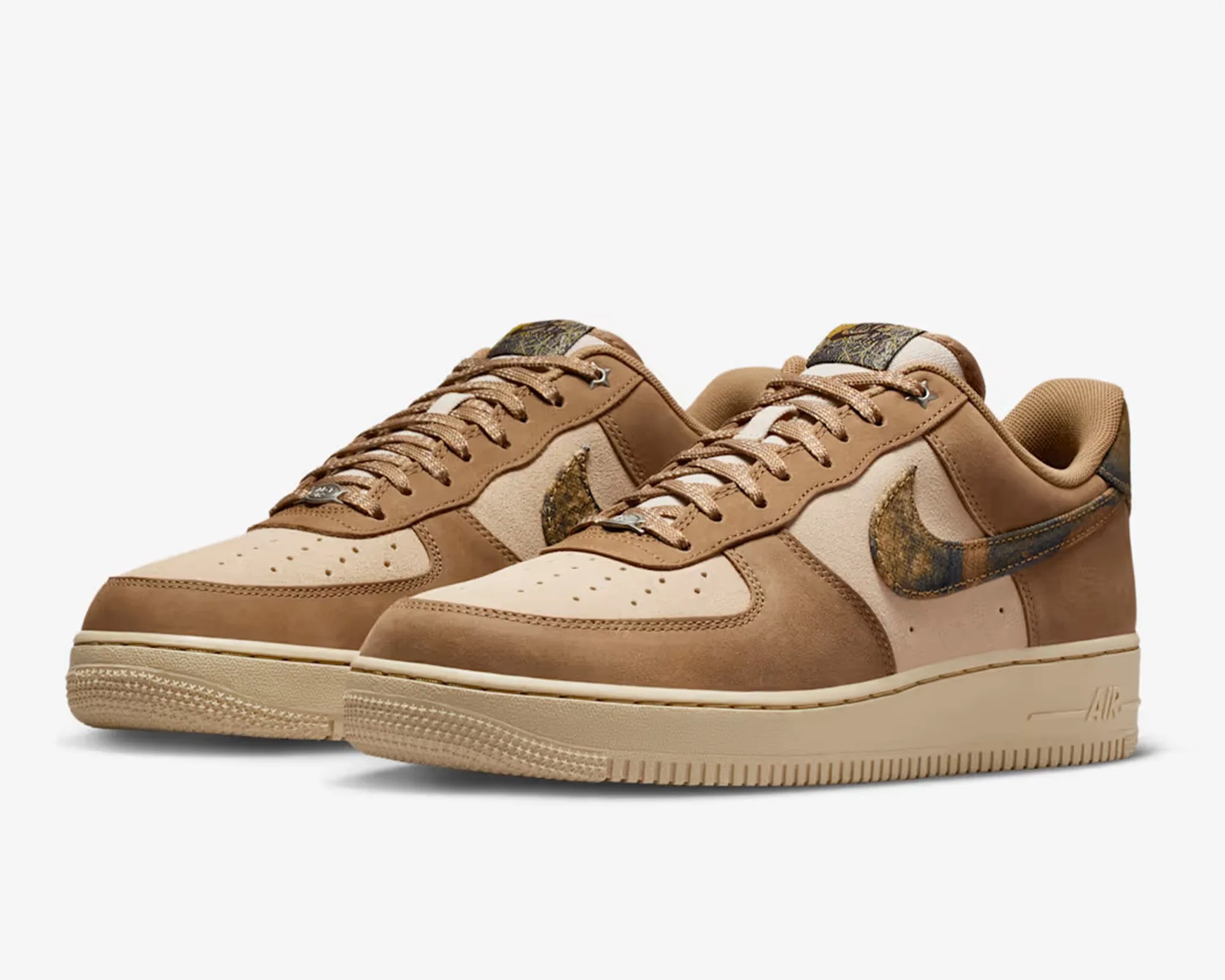 Pair of tan and beige Nike Air Force 1 sneakers with textured brown and black swoosh logos.