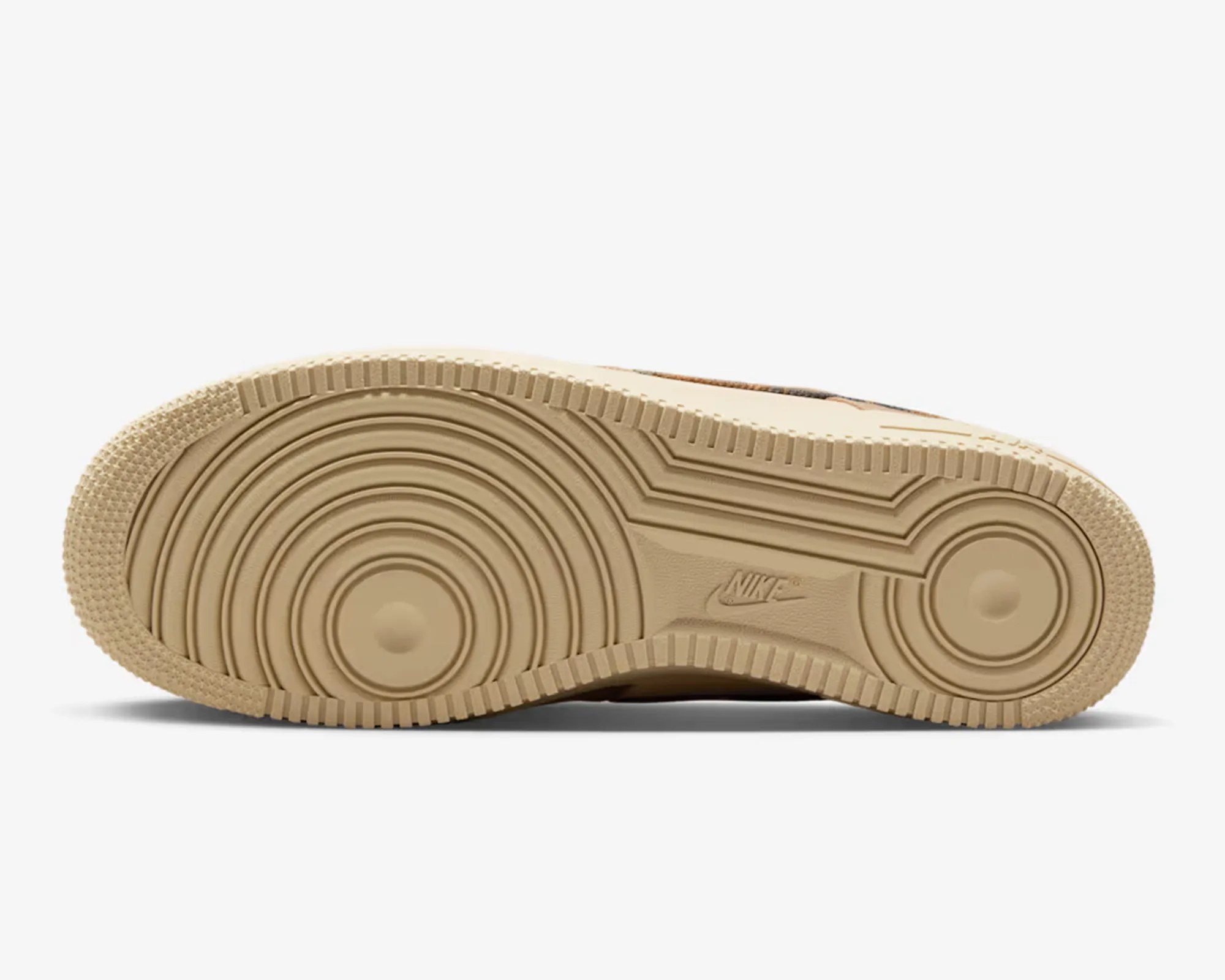 Beige Nike sneaker sole with circular tread patterns and the Nike logo embossed in the center.