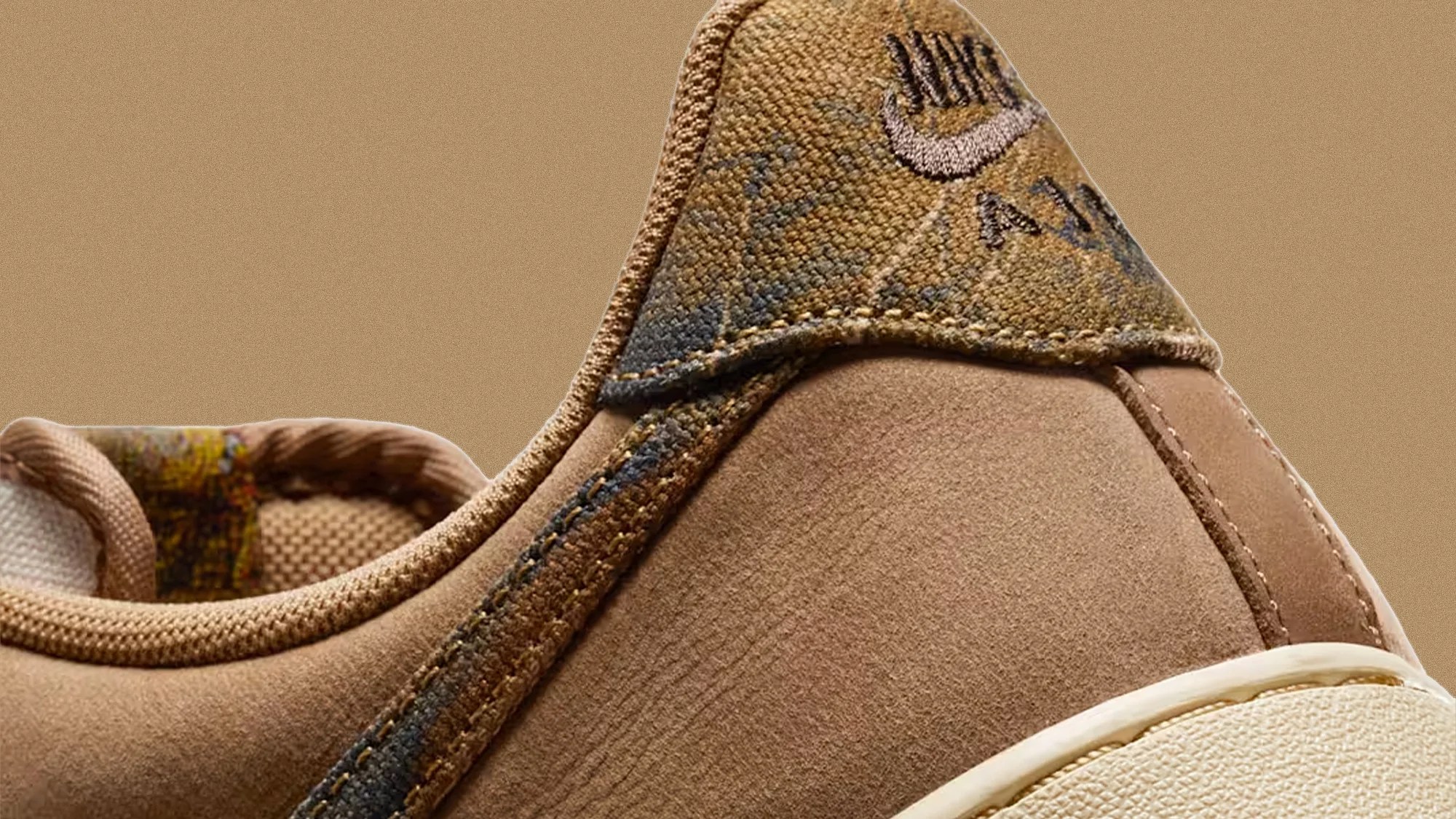 Close-up of the heel area of a tan Nike Air sneaker with textured fabric and suede materials.