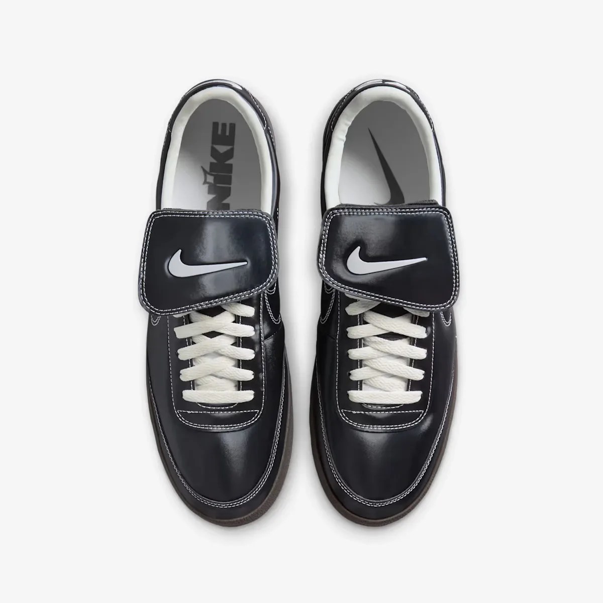 Pair of black Nike sneakers with white laces and large black velcro straps featuring white Nike swooshes.