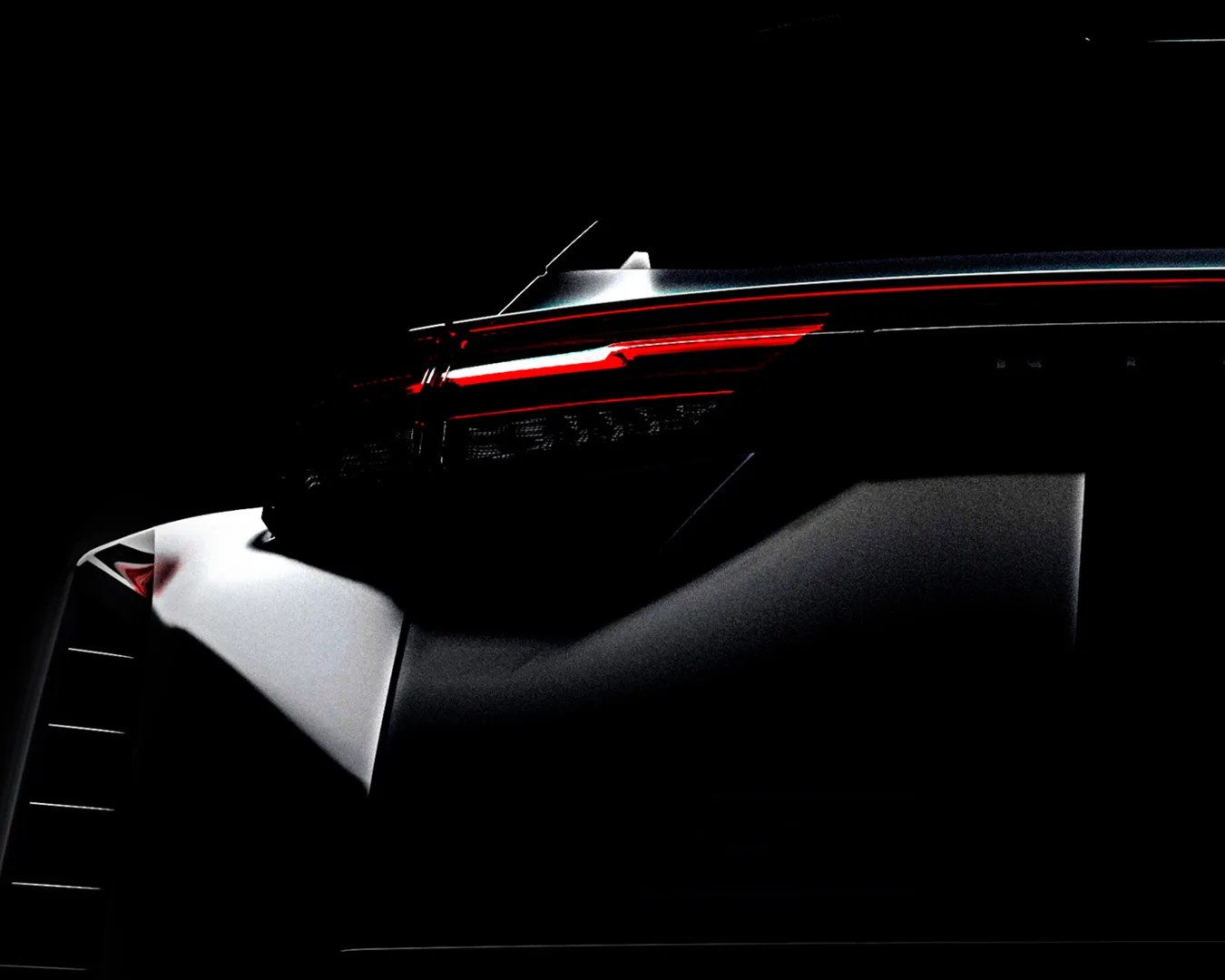 Rear section of a car with illuminated red taillights and a white body panel in low light.