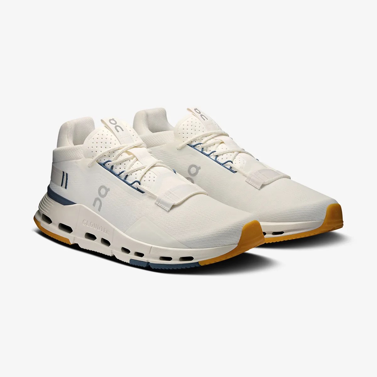 Pair of off-white athletic shoes with blue and mustard accents and perforated tongue panels.