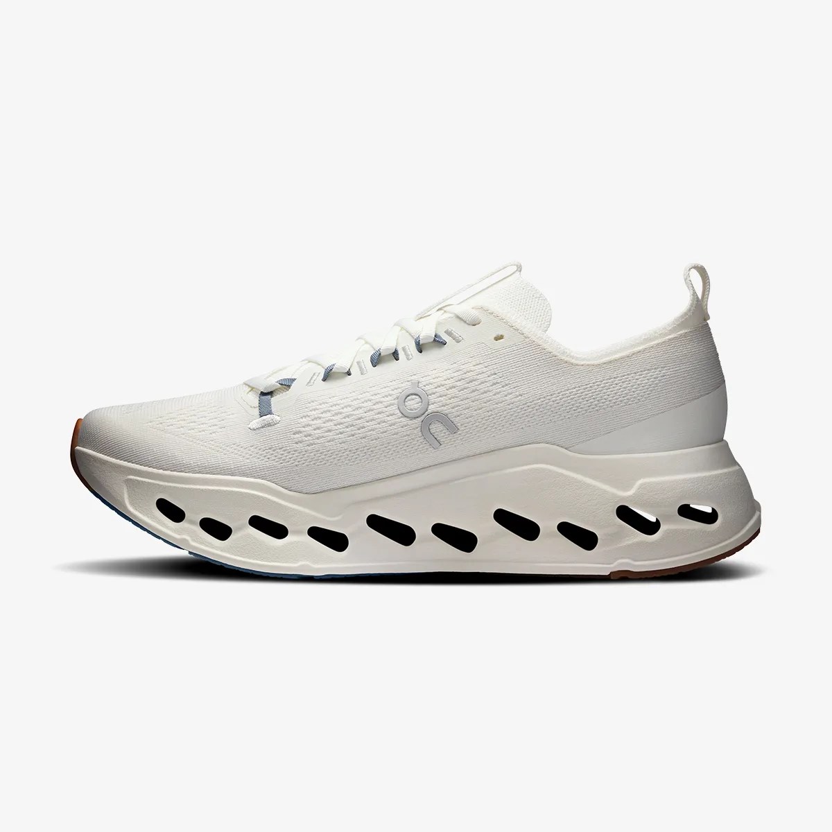White athletic sneaker with a thick sole featuring black oval cutouts and a gray logo on the side.