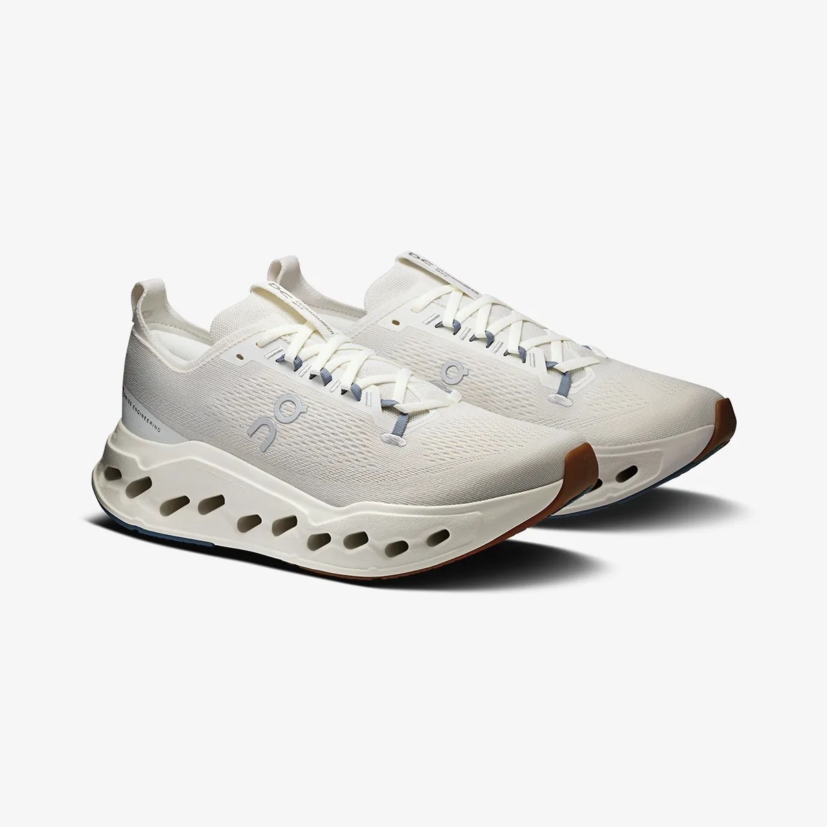 Pair of off-white athletic shoes with perforated thick soles and light gray logo on the sides.