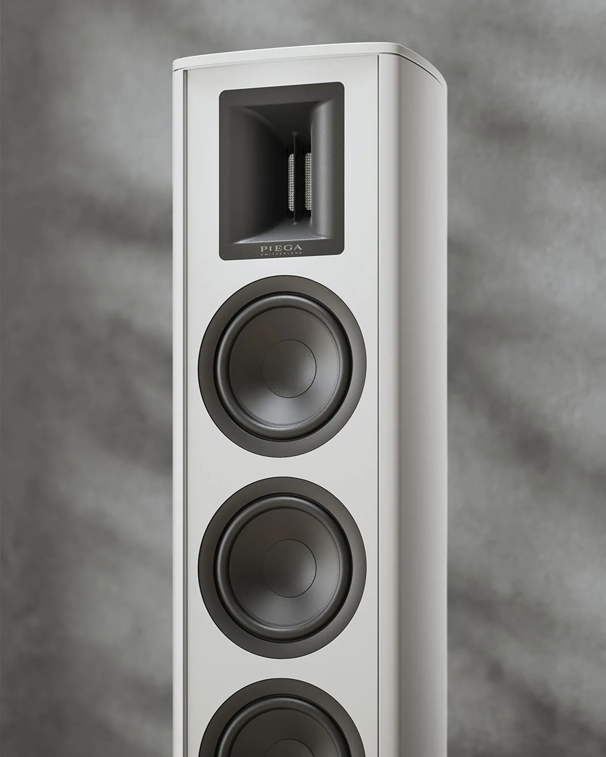 Tall white floor-standing speaker with three black drivers and a rectangular tweeter at the top.