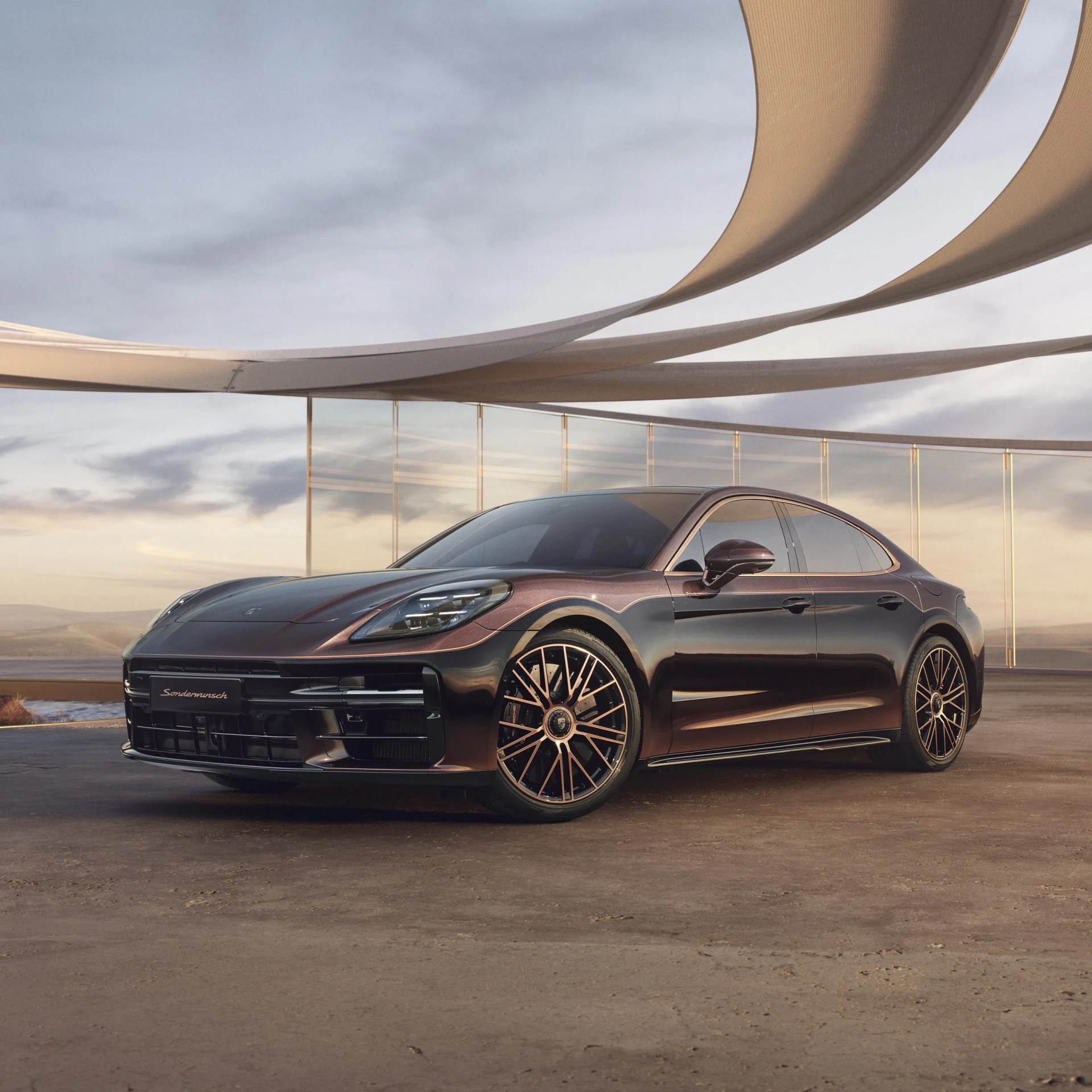 Metallic dark brown Porsche sedan with bronze-accented multi-spoke wheels parked on a concrete surface.