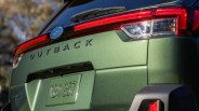 Rear view of a green Subaru Outback with visible taillights and license plate TBQ 857.
