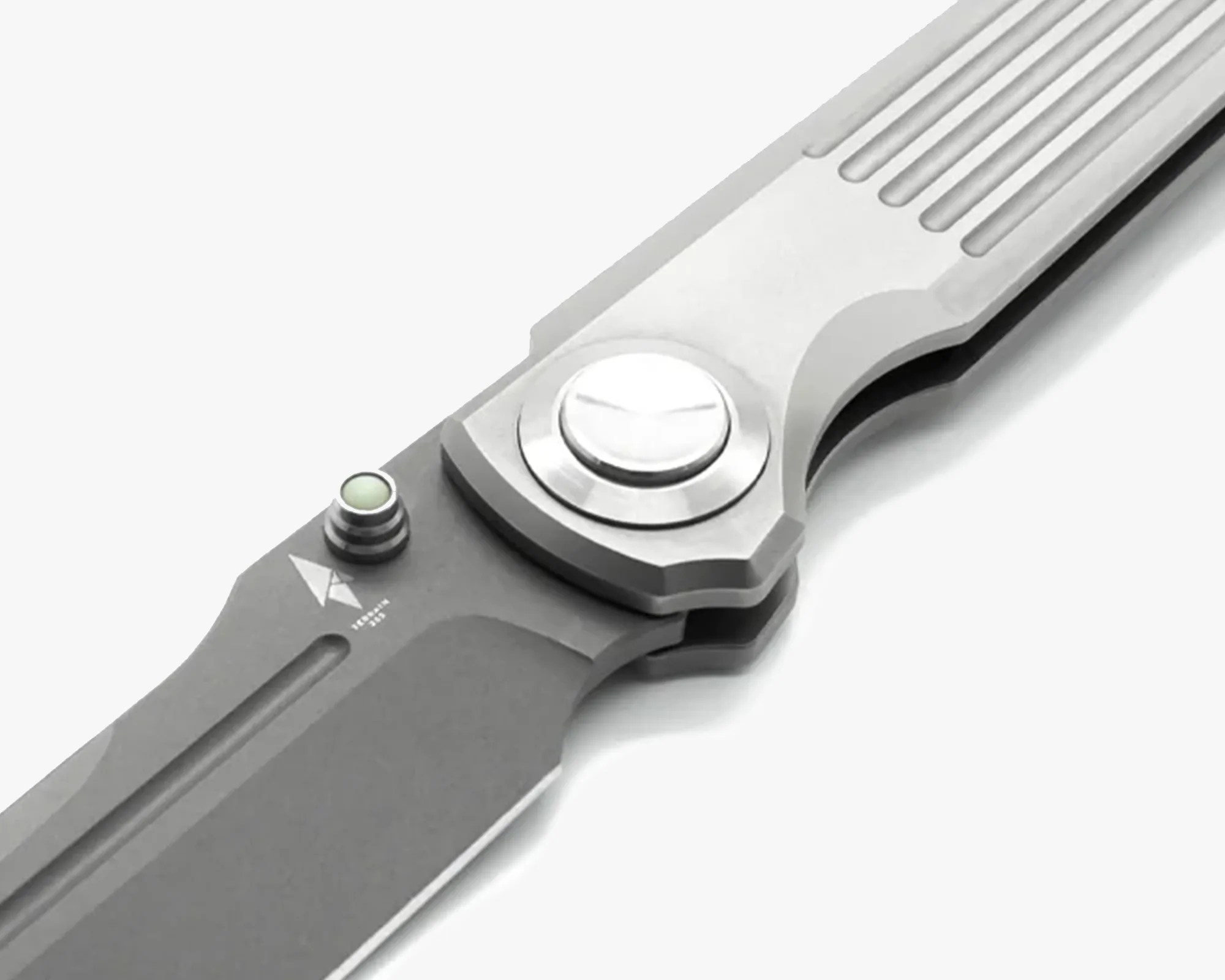Close-up of a gray folding knife with a textured handle and a thumb stud near the blade pivot.