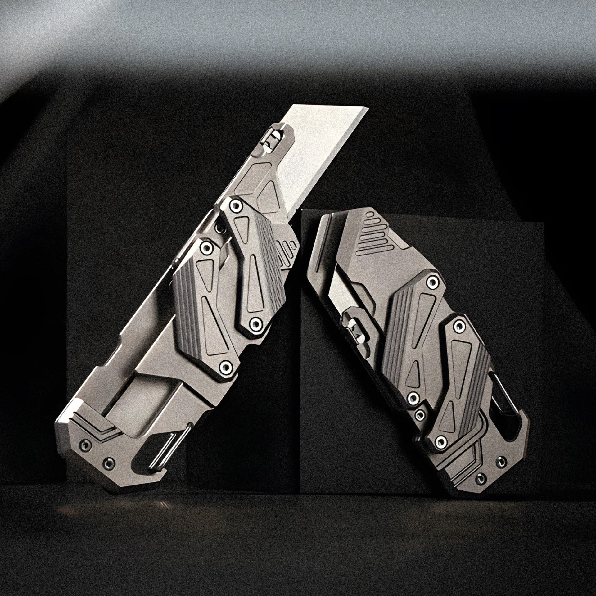 Two futuristic metallic folding knives with angular designs, one open and one closed, on a dark background.