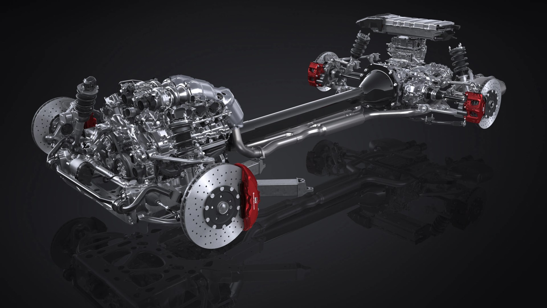 Silver car engine and suspension system with red brake calipers on a dark reflective surface.