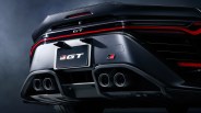 Rear view of a dark metallic GR GT car with quad exhaust pipes and a red light strip across the bumper.